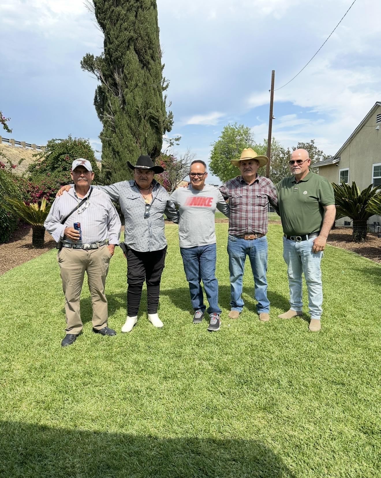 A group of men standing in a grassy area