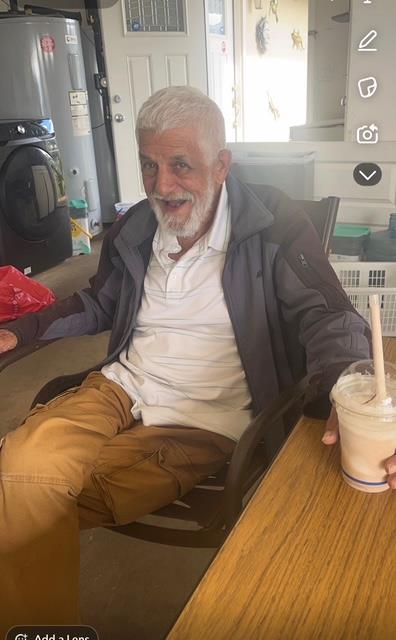 A man sitting at a table with a drink