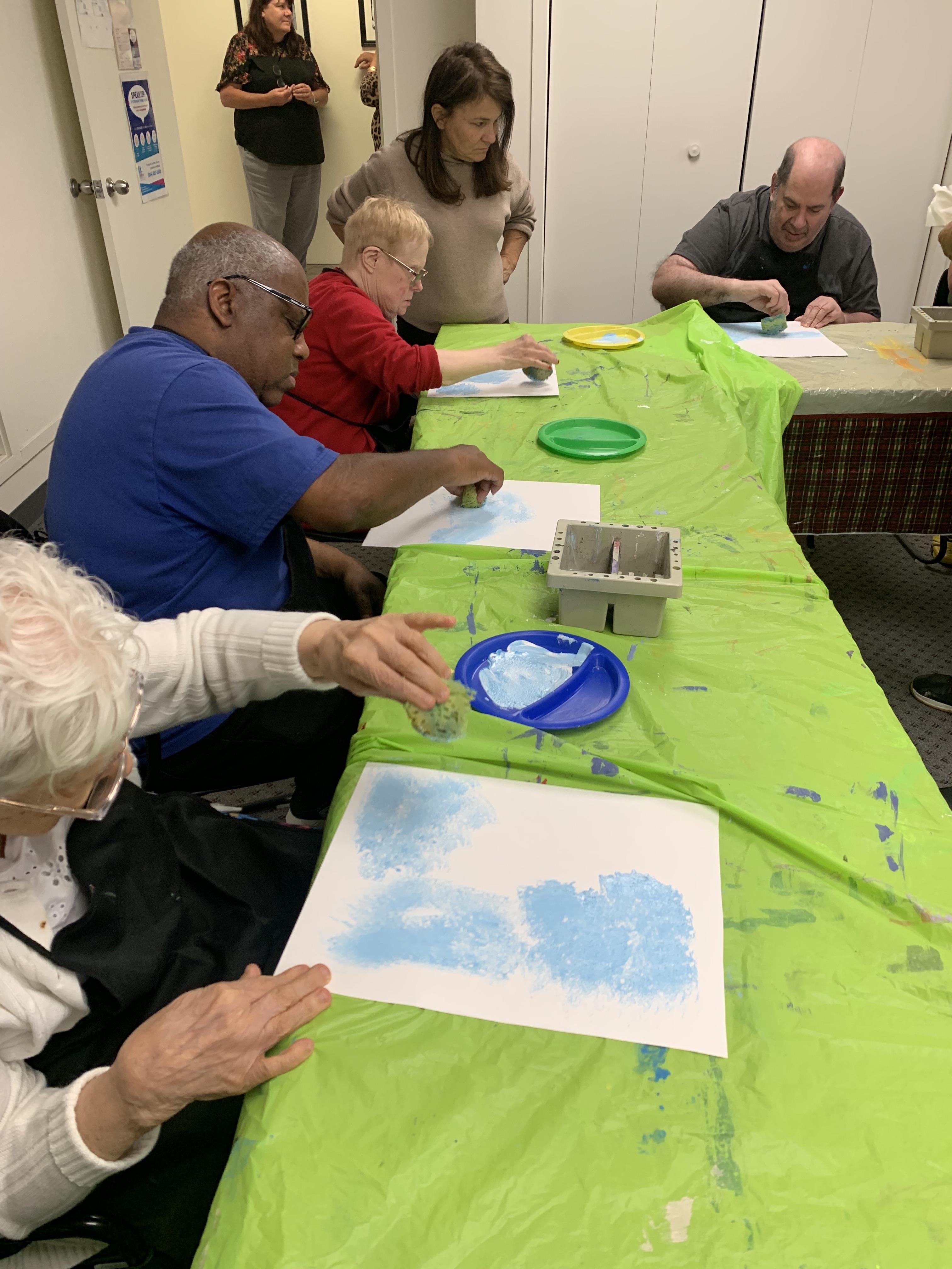 A group of people painting on paper