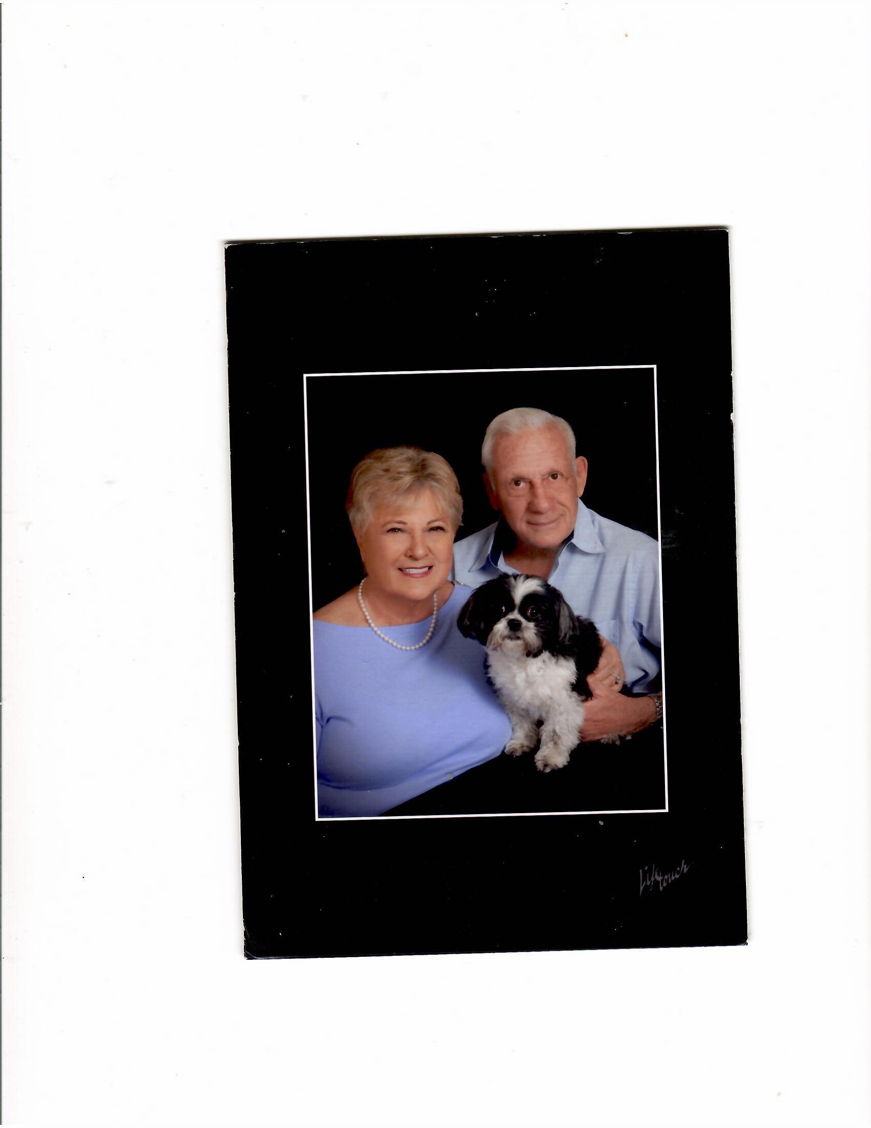 A man and woman holding a dog