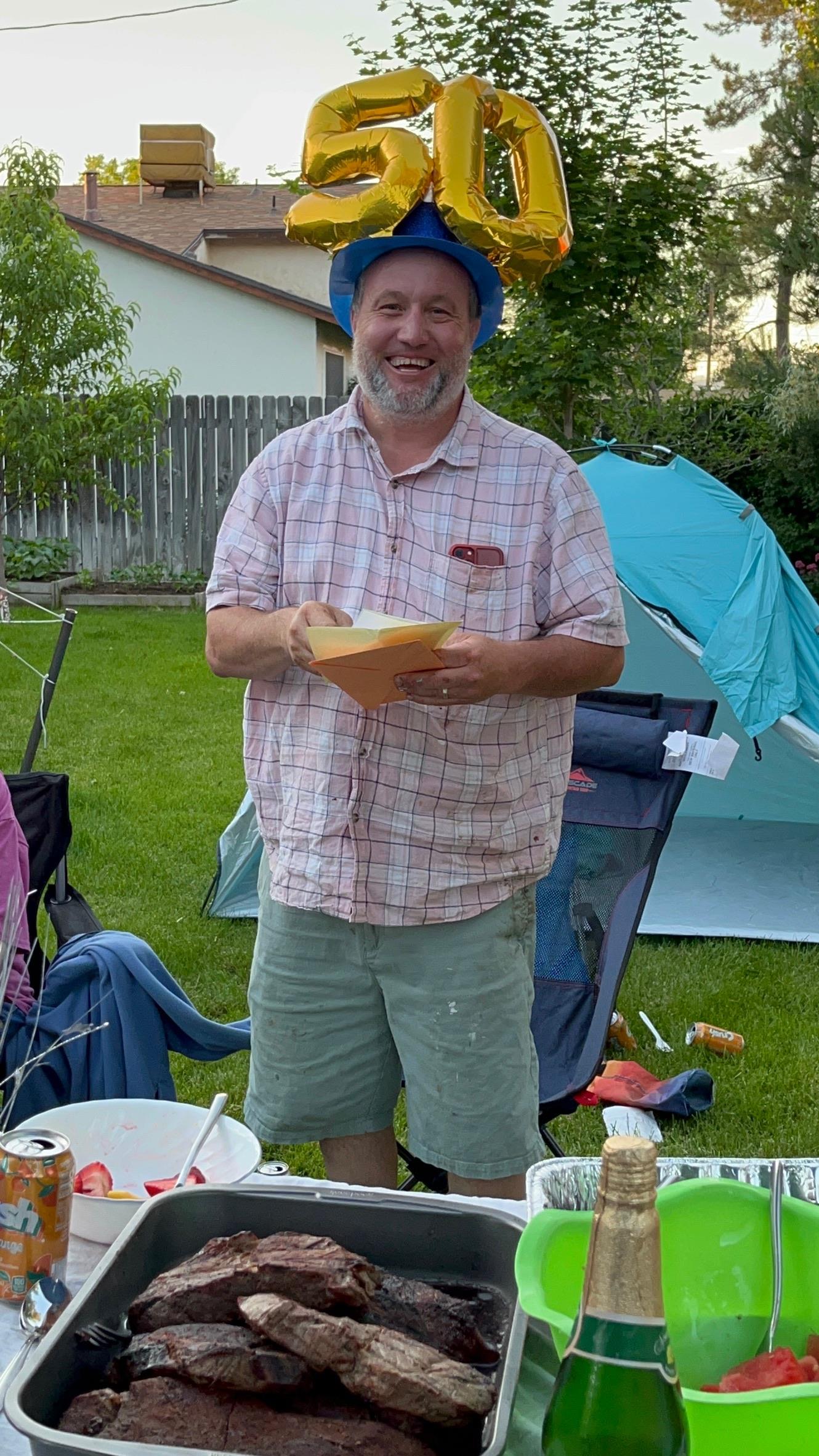 A man wearing a blue hat and holding a yellow envelope
