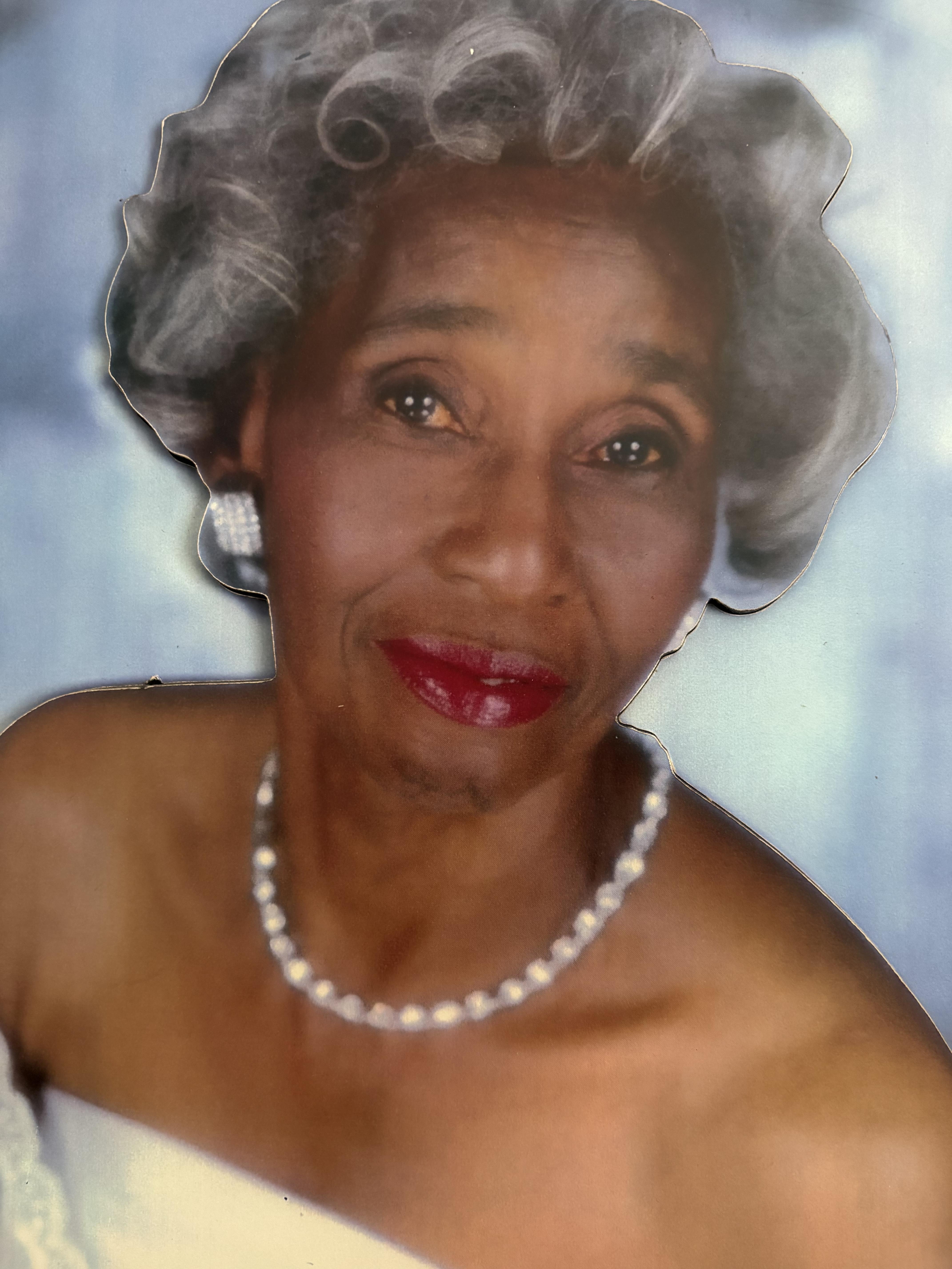 A woman with grey hair and a pearl necklace