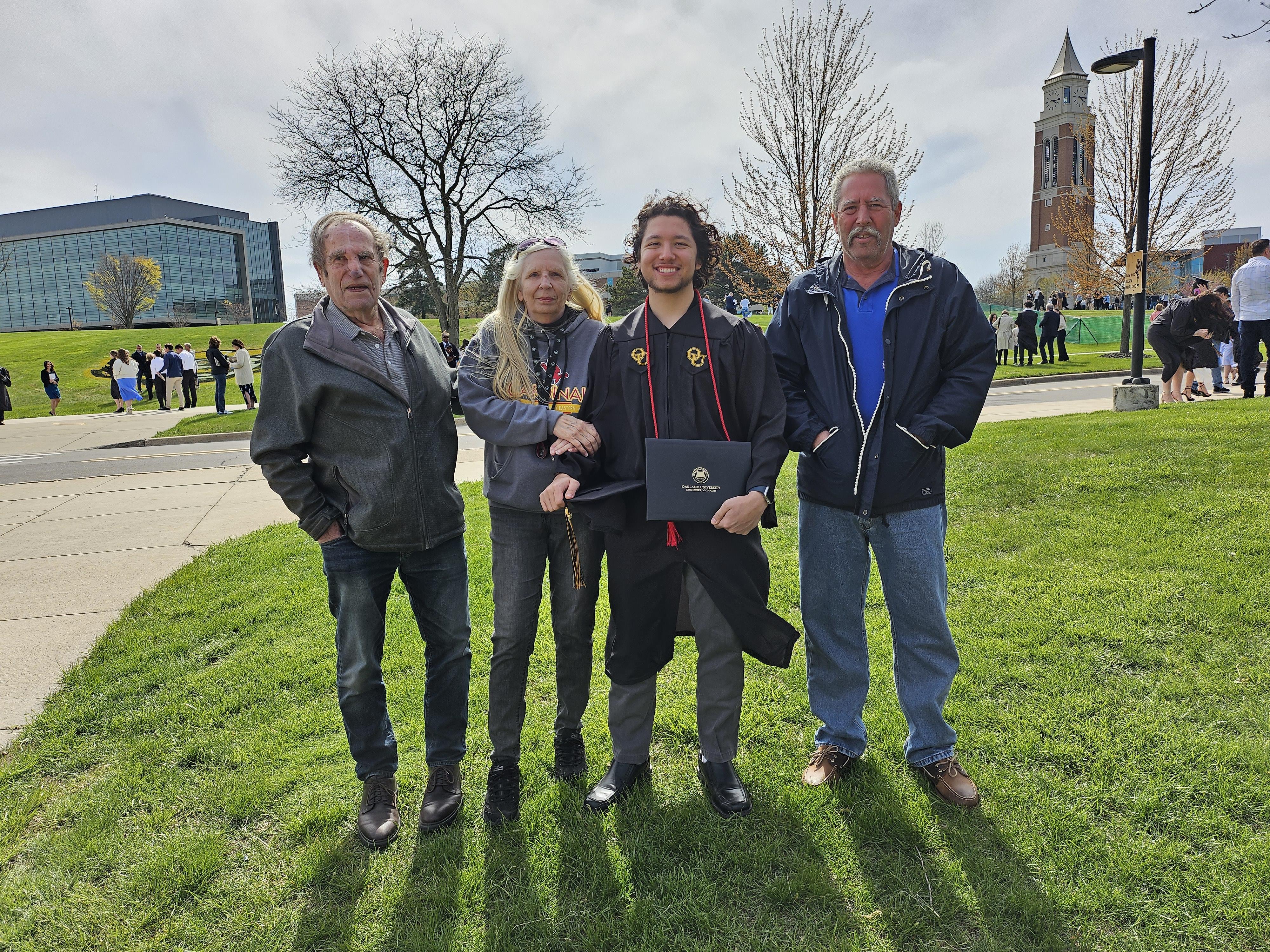 A group of people standing in a grassy area