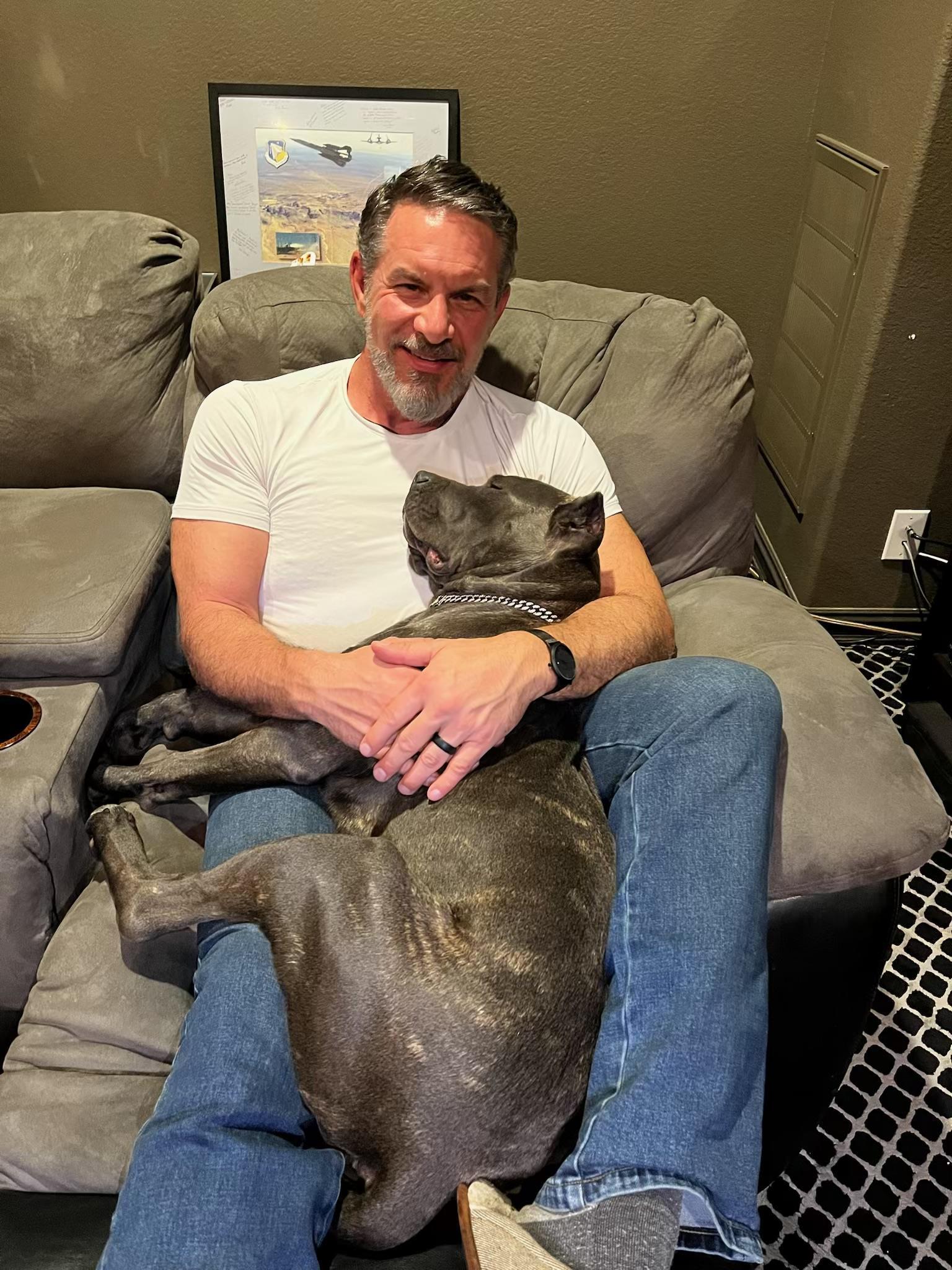 A man sitting on a couch with a dog