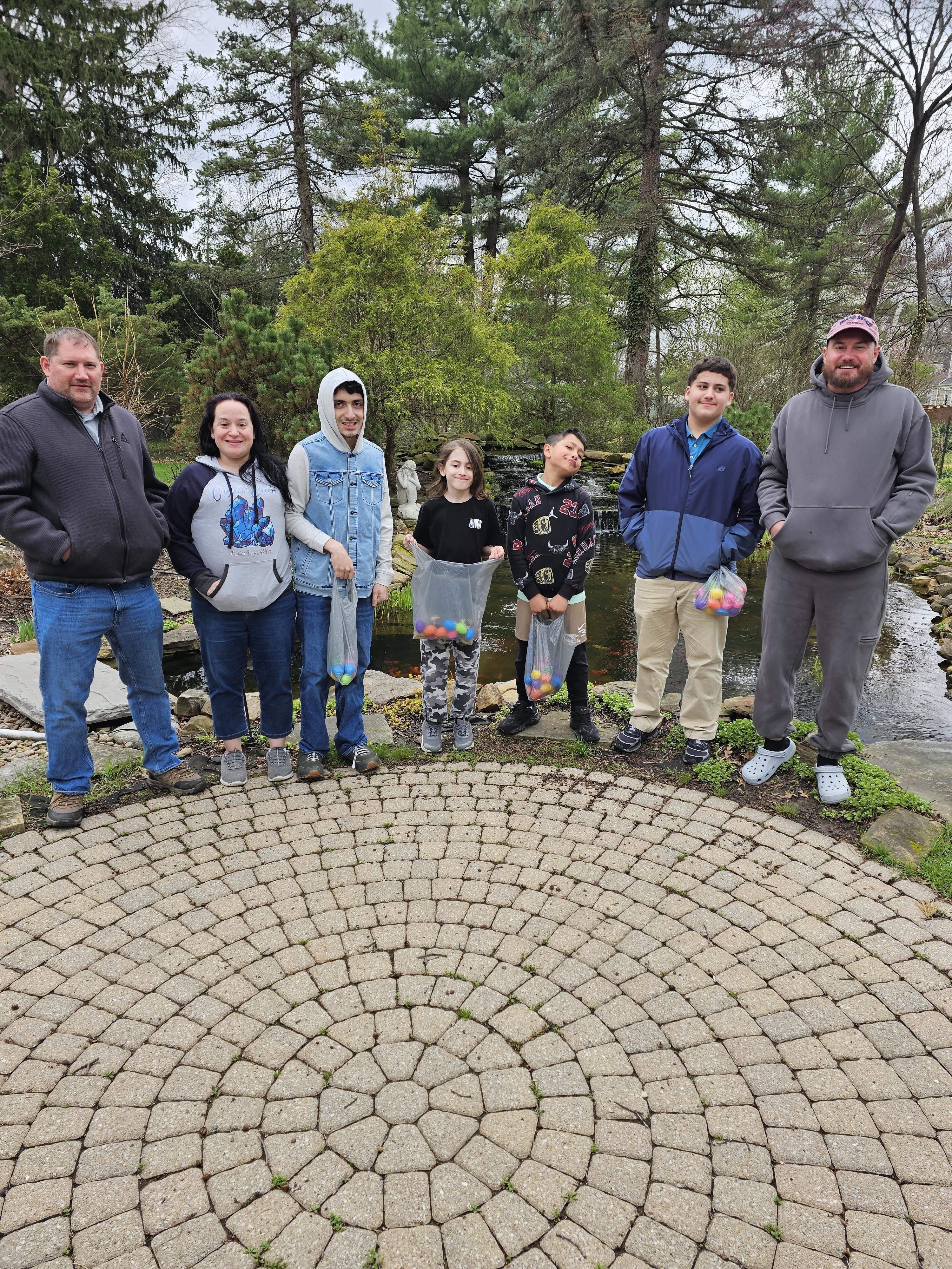 A group of people standing in front of a pond
