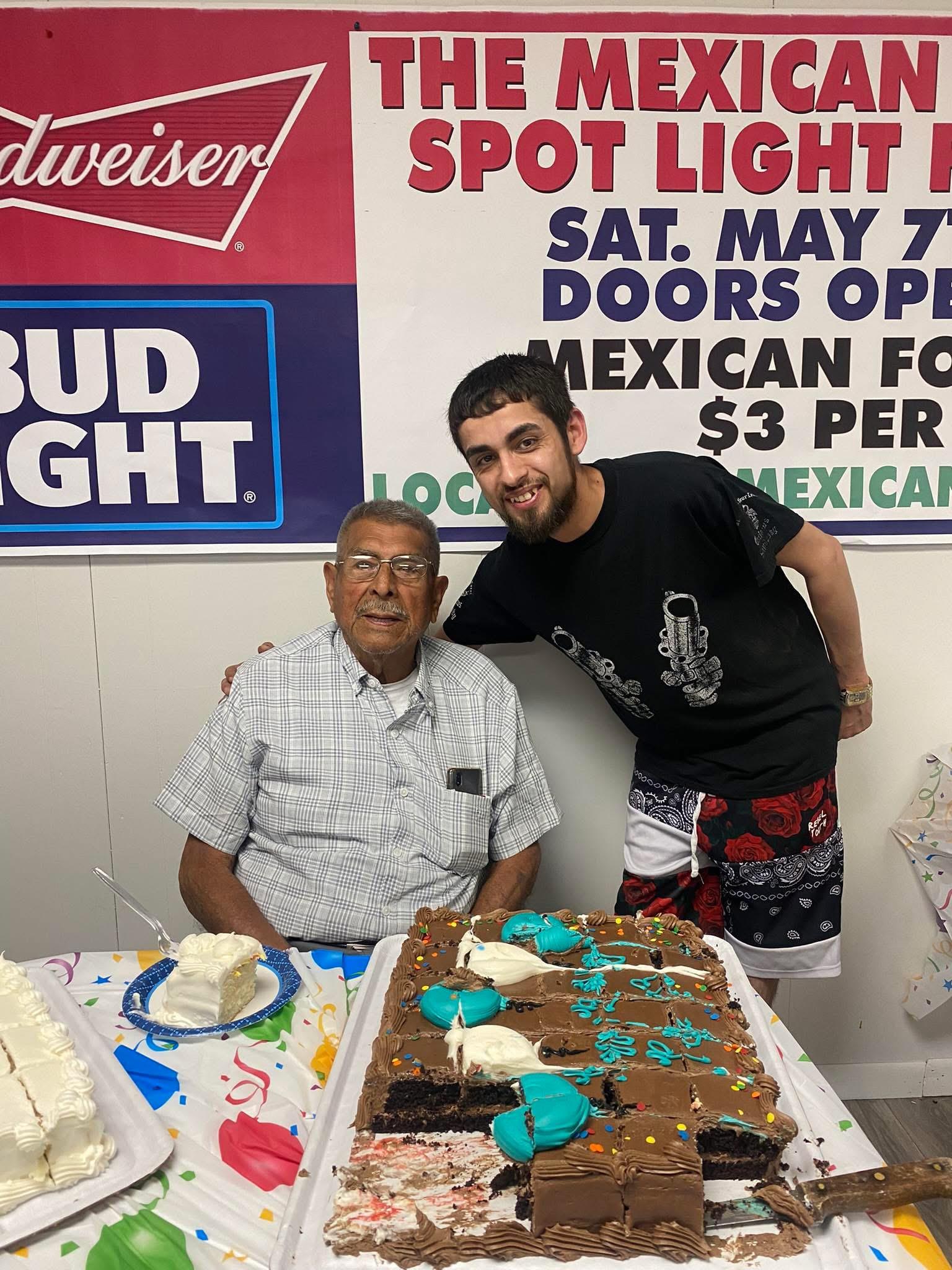 A man standing next to a cake