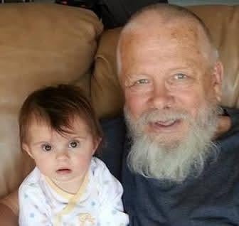 A man and baby sitting on a couch