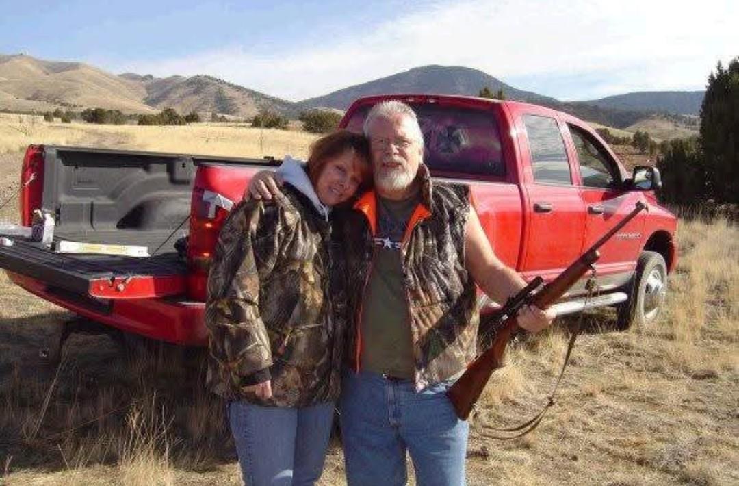 A man and woman standing next to a red truck