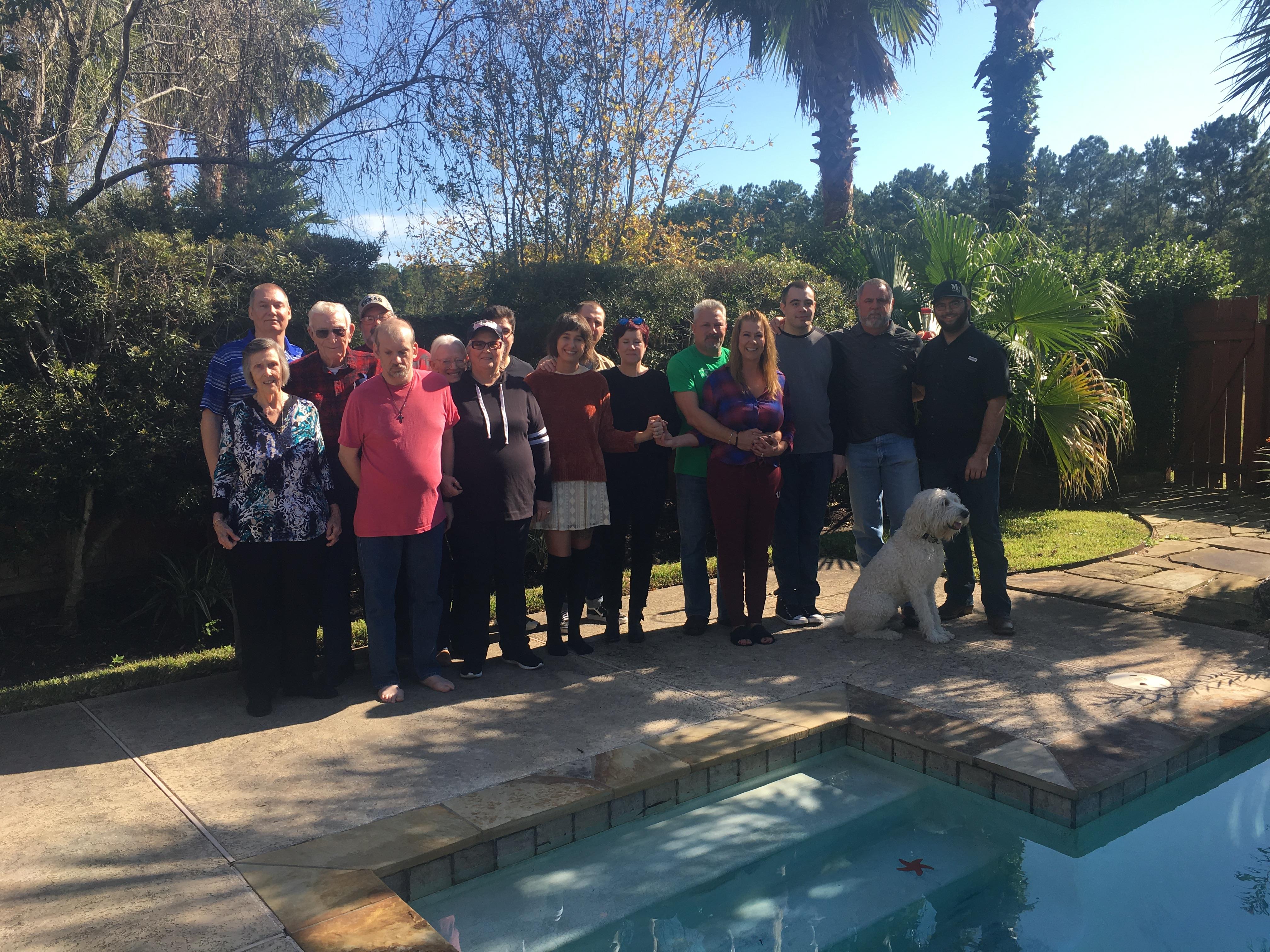 A group of people standing in front of a pool