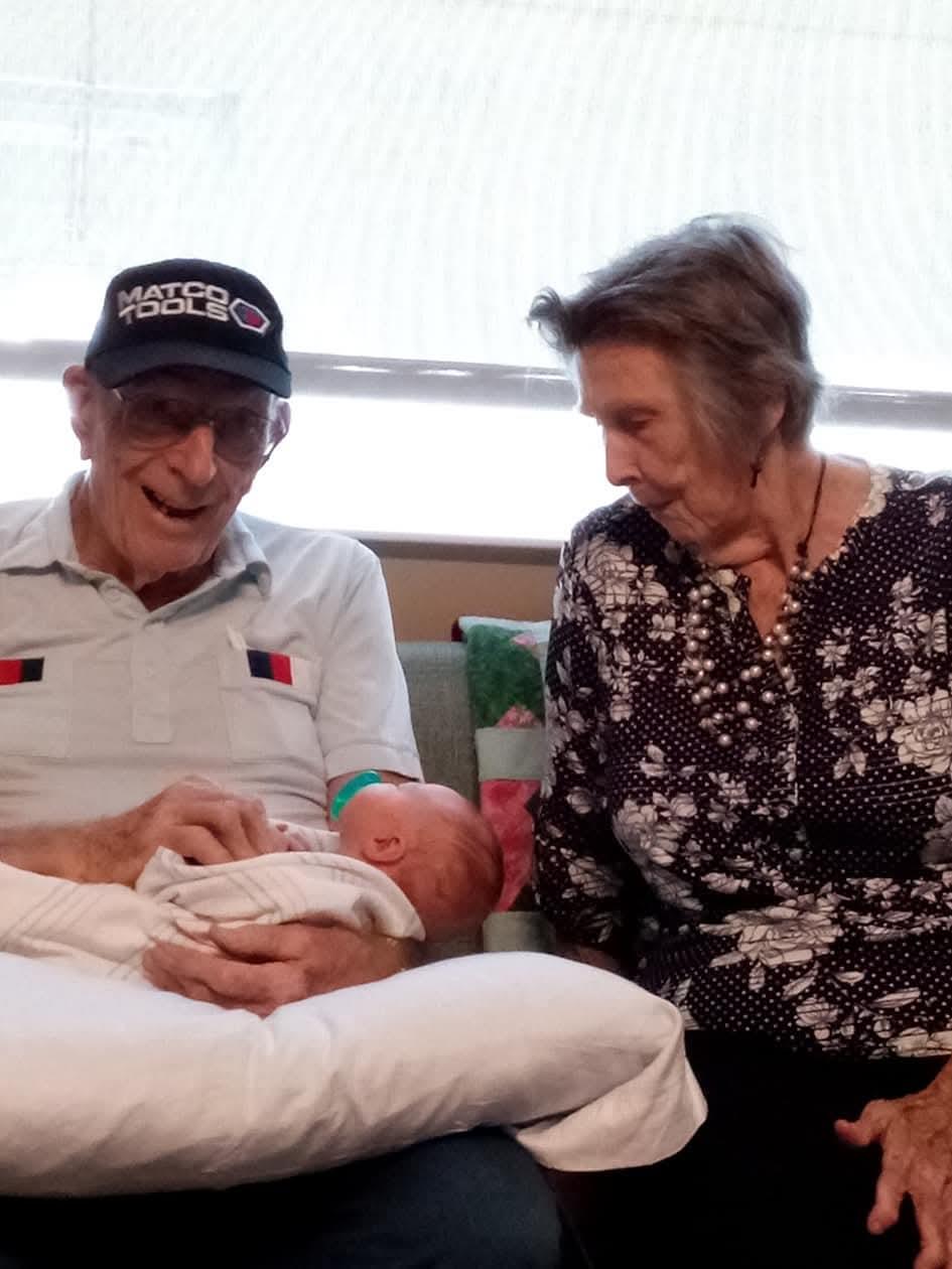 A man and woman holding a baby