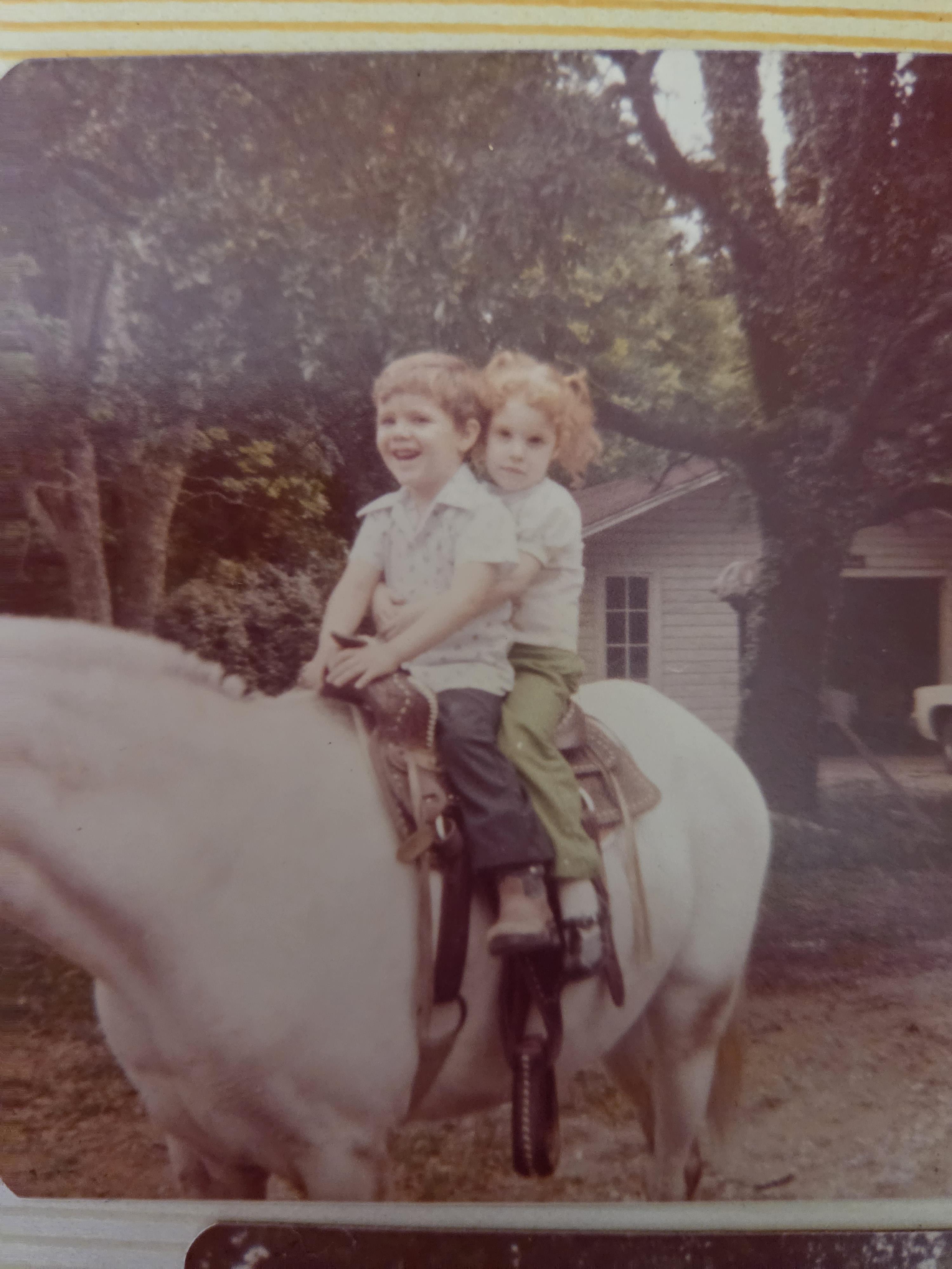 Two children riding a horse