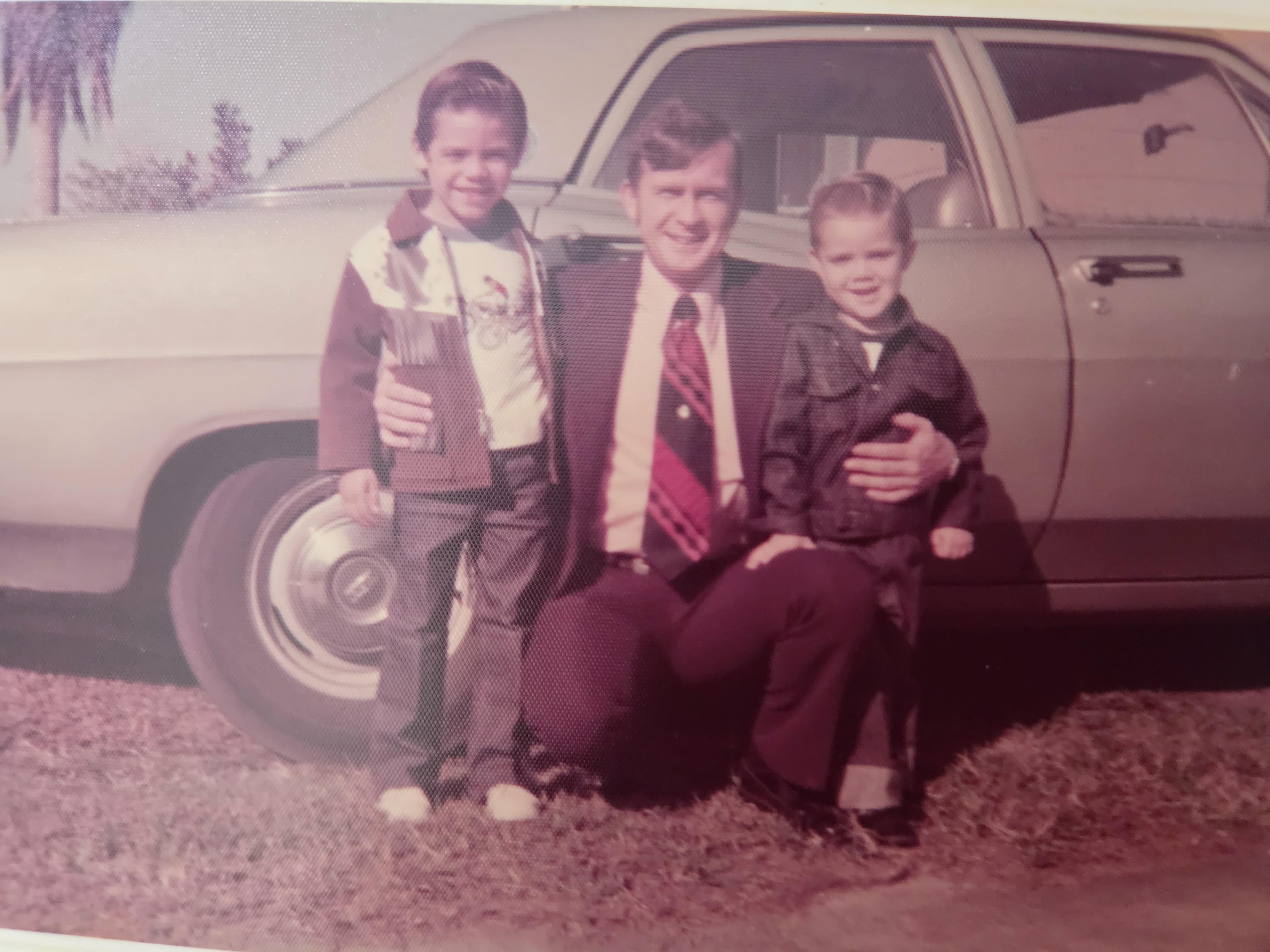 A man and two boys posing for a picture