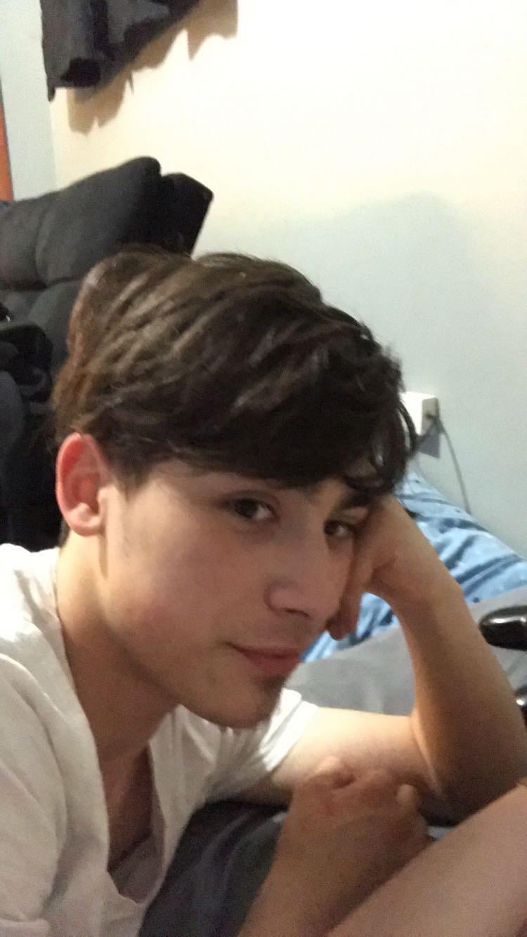 A boy with his hand on his head
