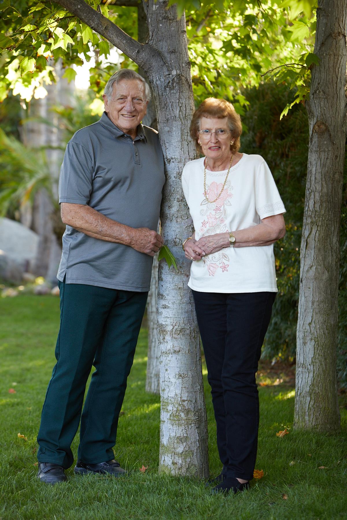 A man and woman standing next to a tree