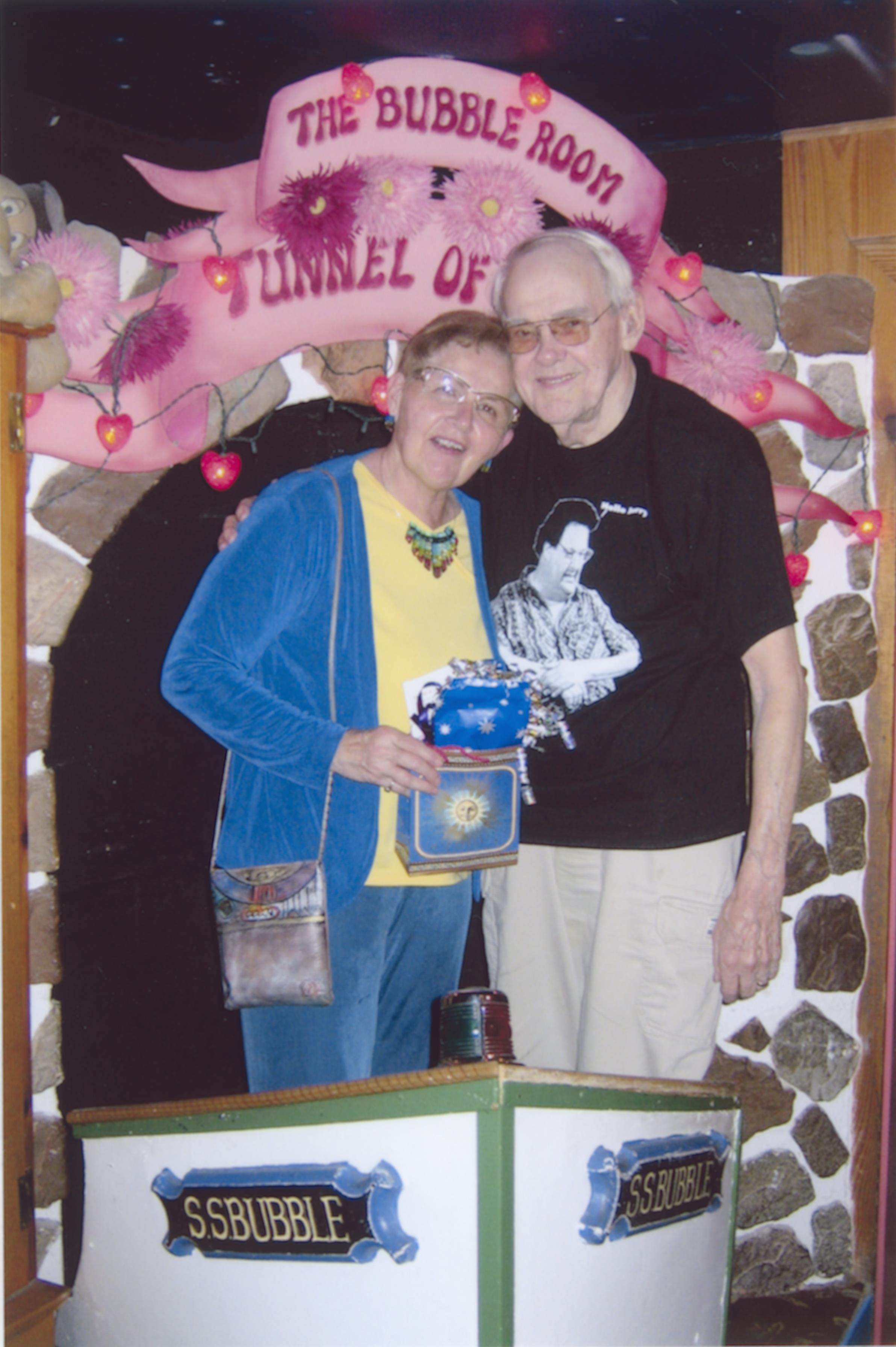 A man and woman standing in front of a sign