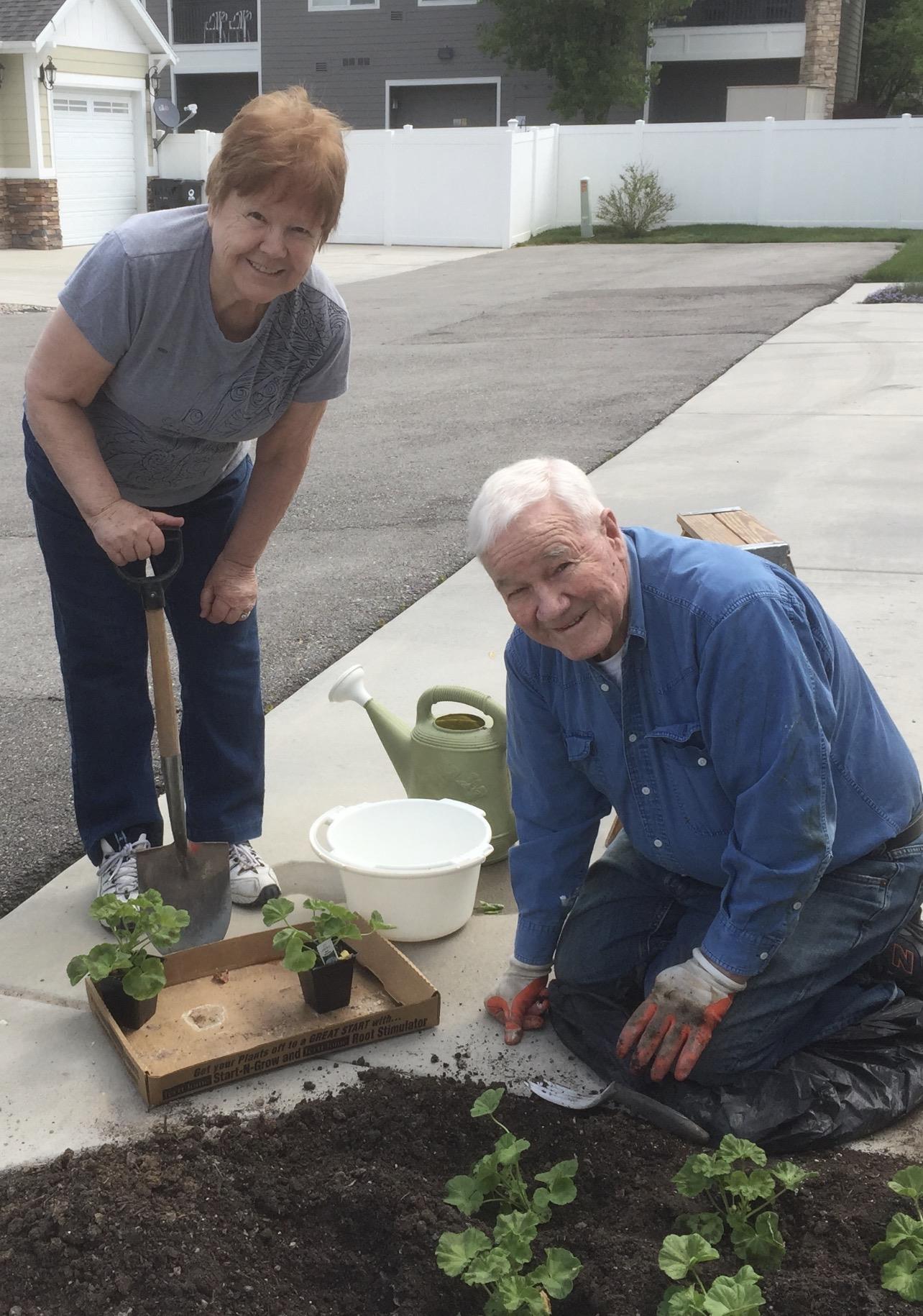 A man and woman planting a plant