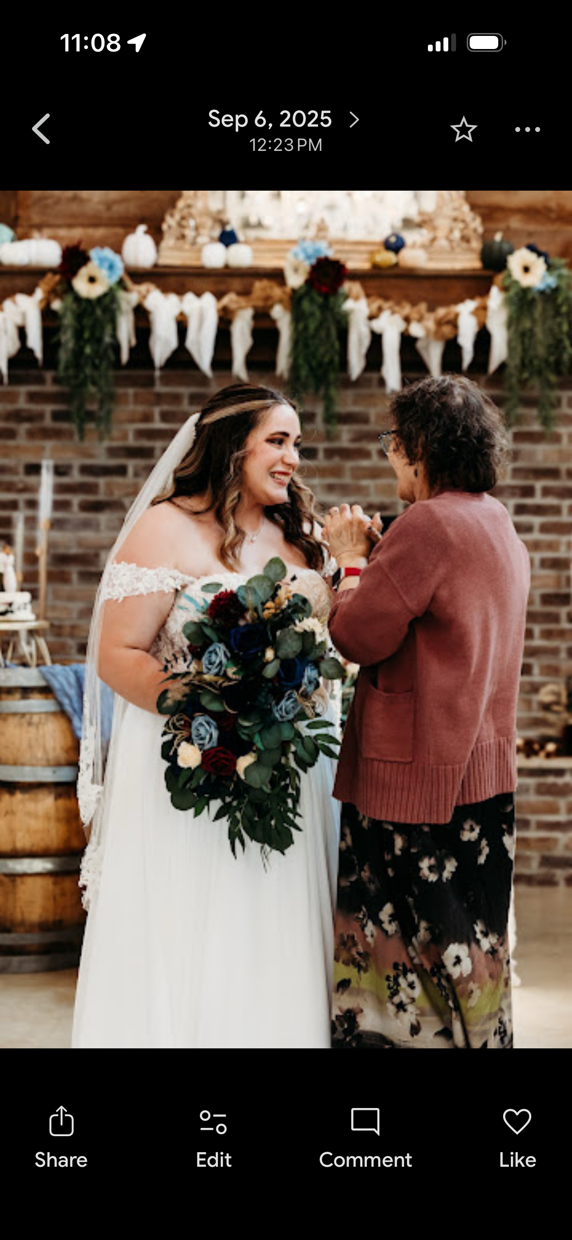 A woman holding a bouquet of flowers and a woman standing next to a brick wall