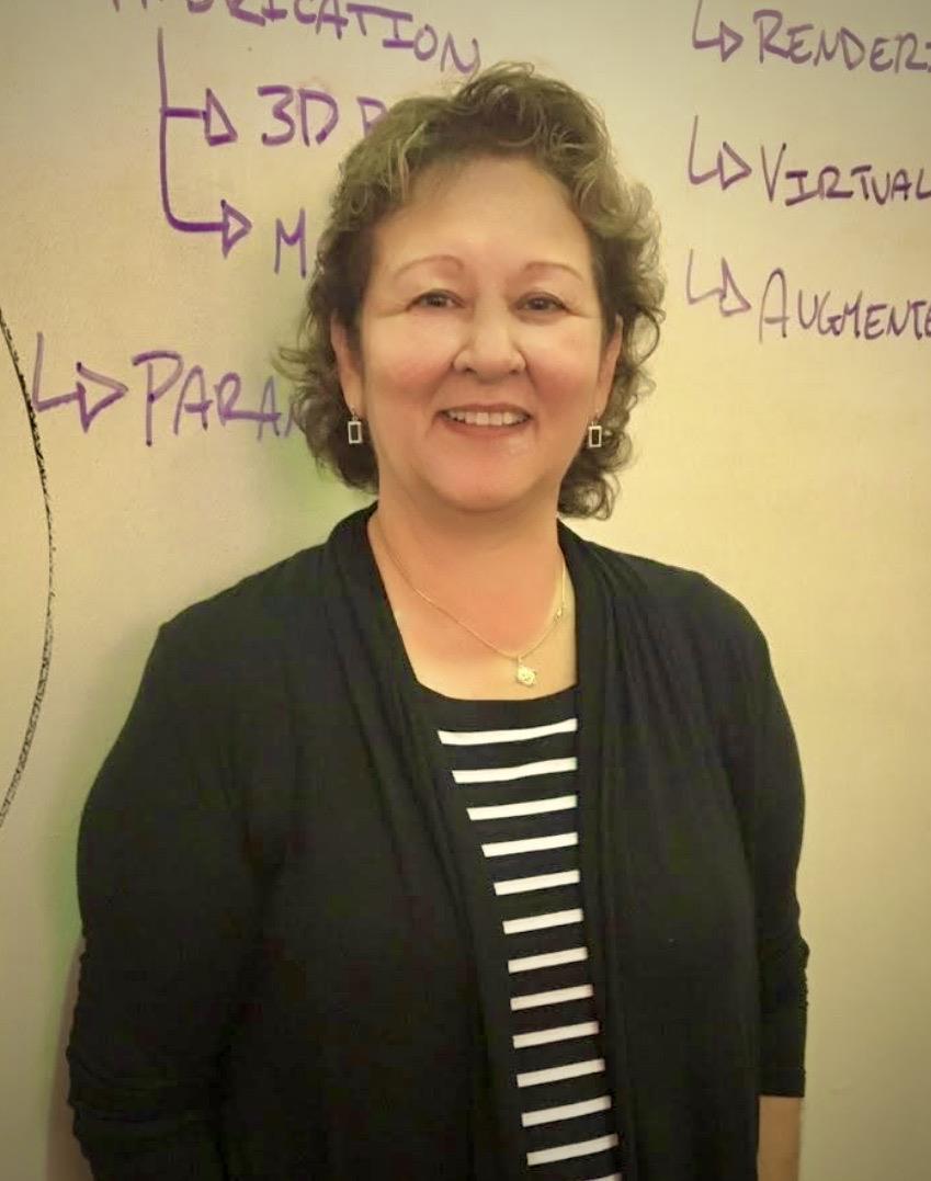 A woman smiling in front of a whiteboard