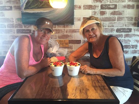 Two women sitting at a table with food in bowls
