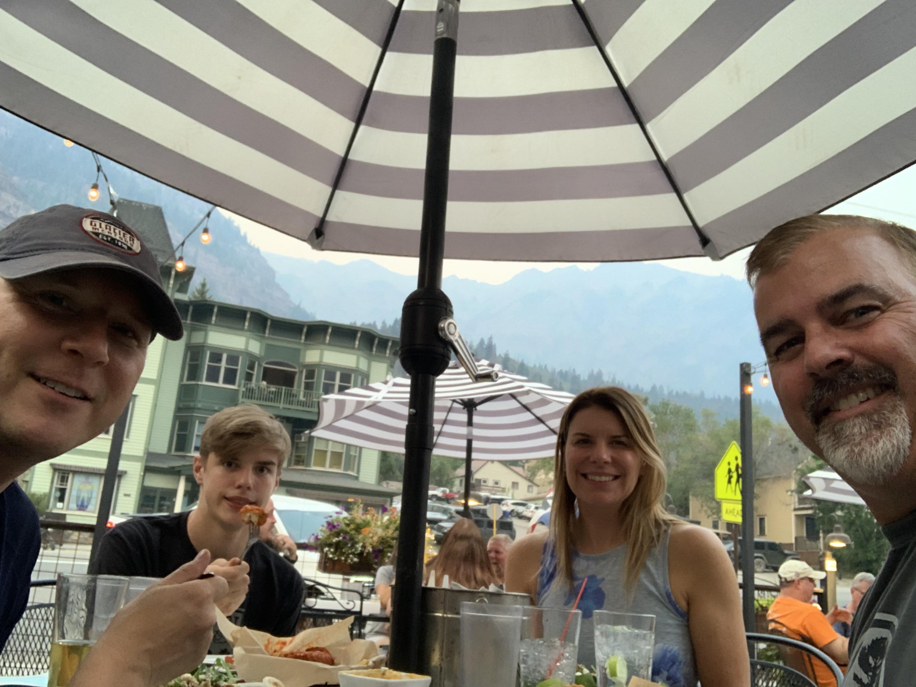 A group of people sitting under an umbrella