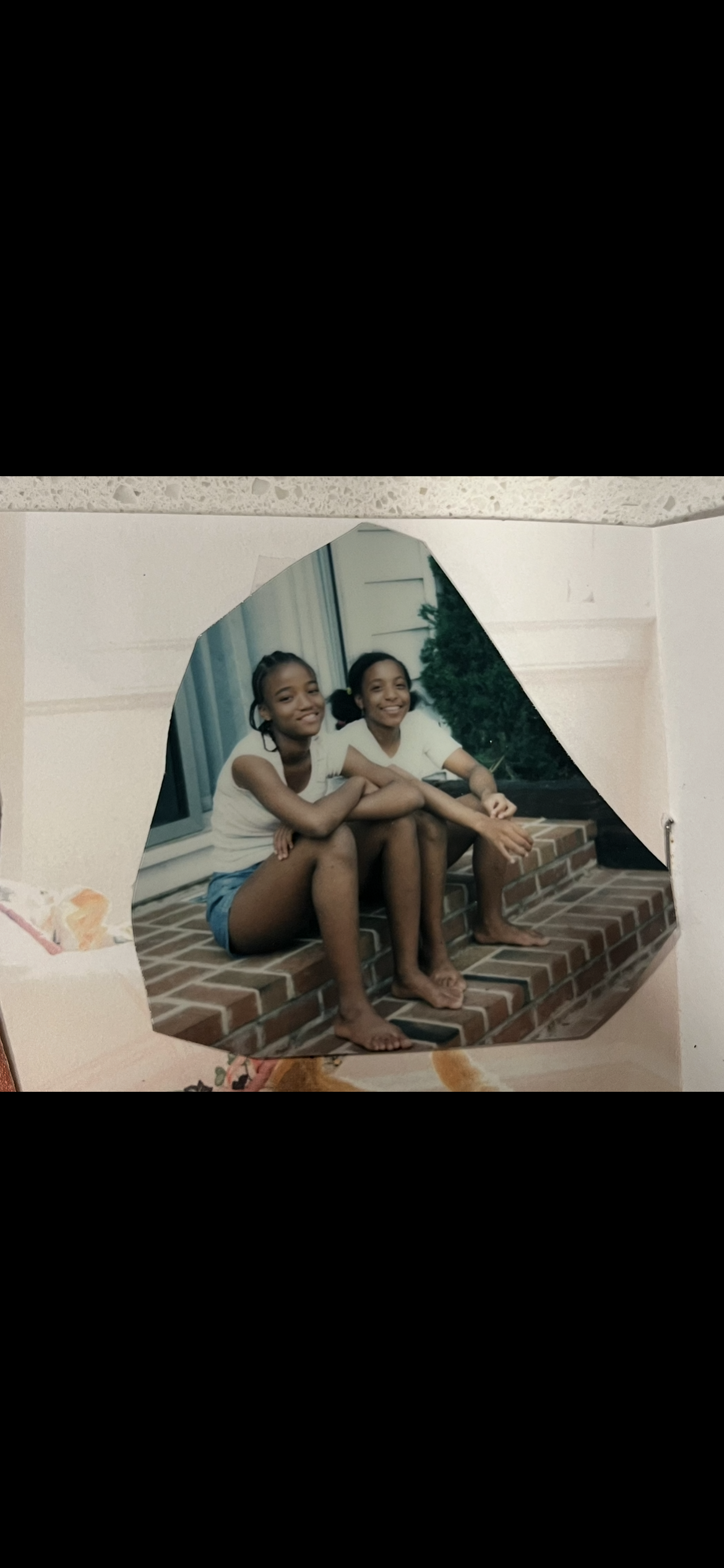 A couple of girls sitting on a brick staircase