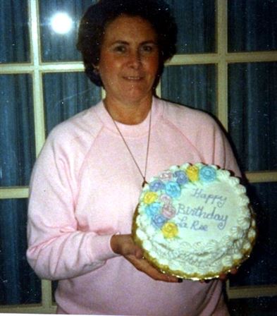 A woman holding a birthday cake