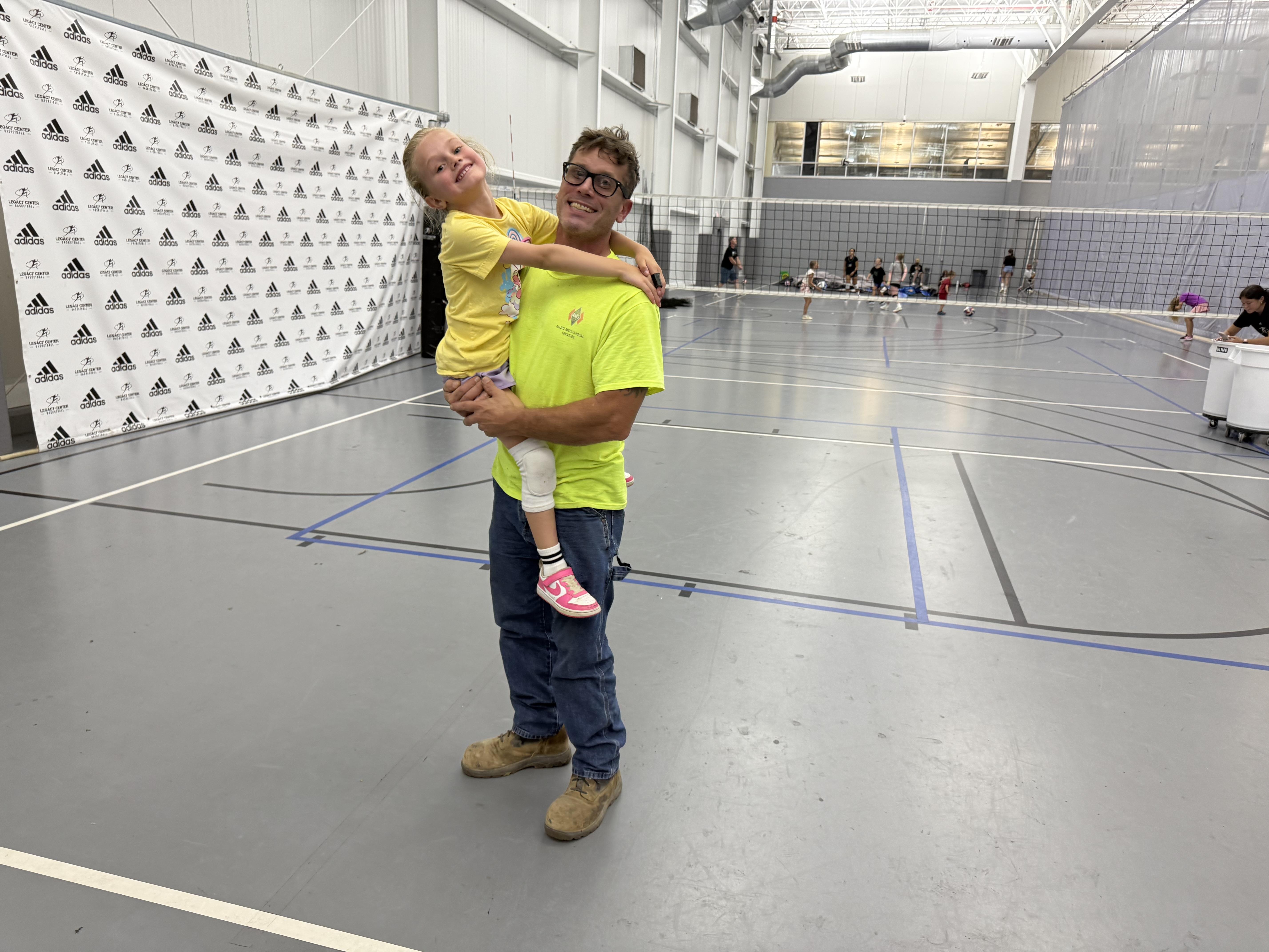 A man holding a girl in a gym