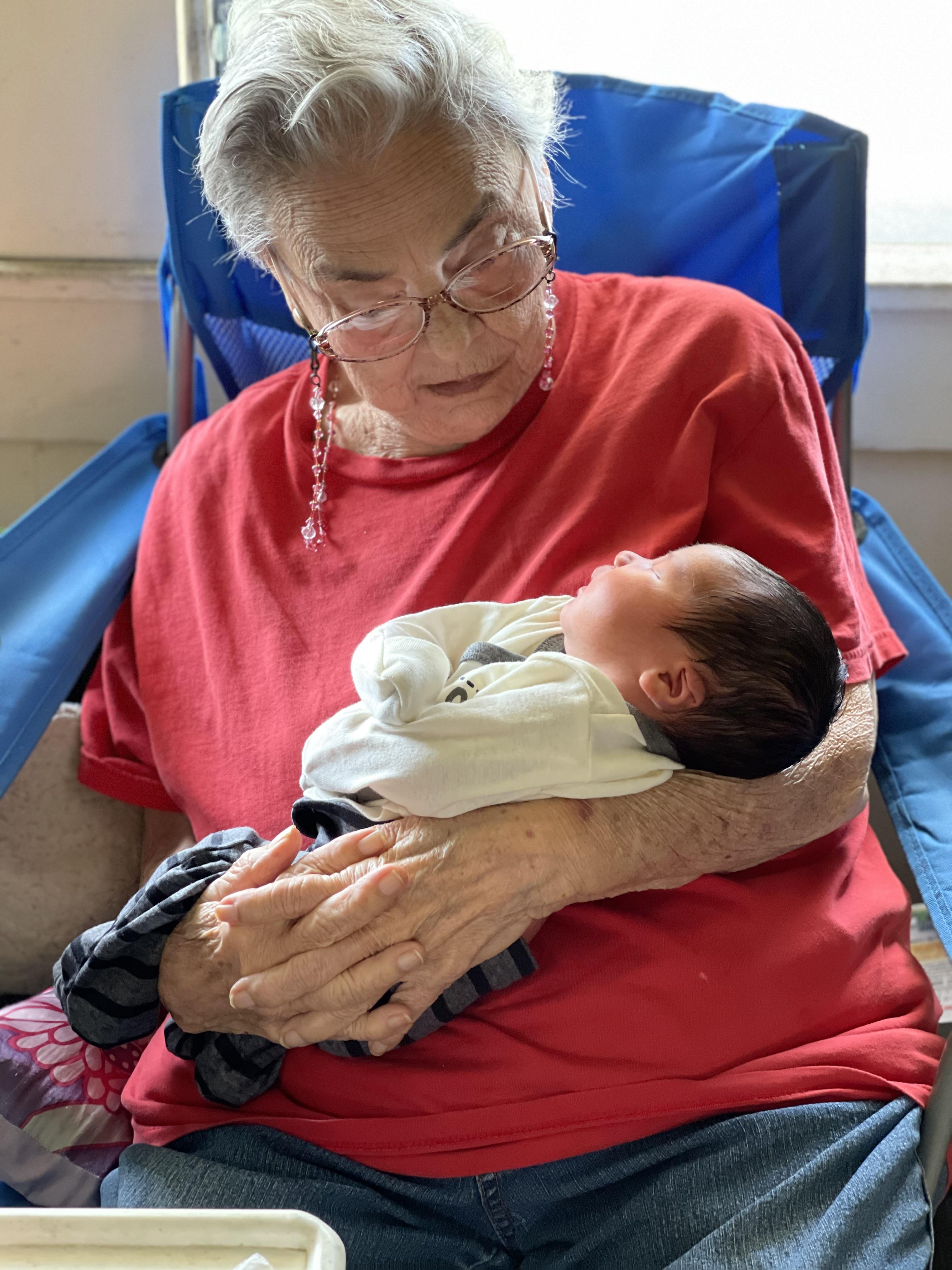 An old woman holding a baby