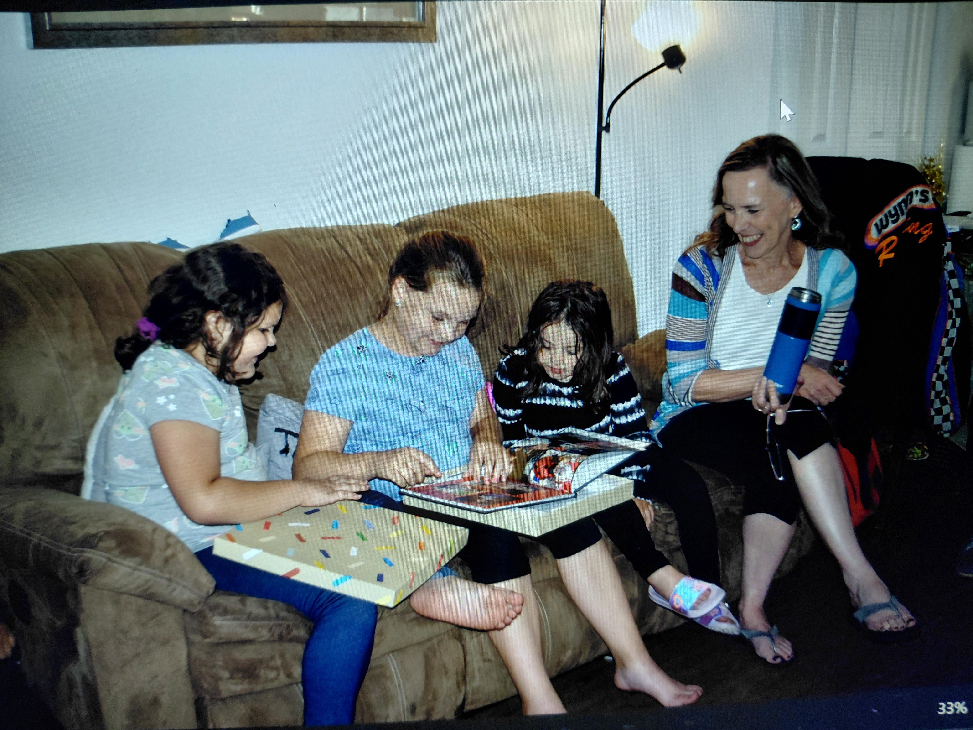A group of people sitting on a couch reading a book