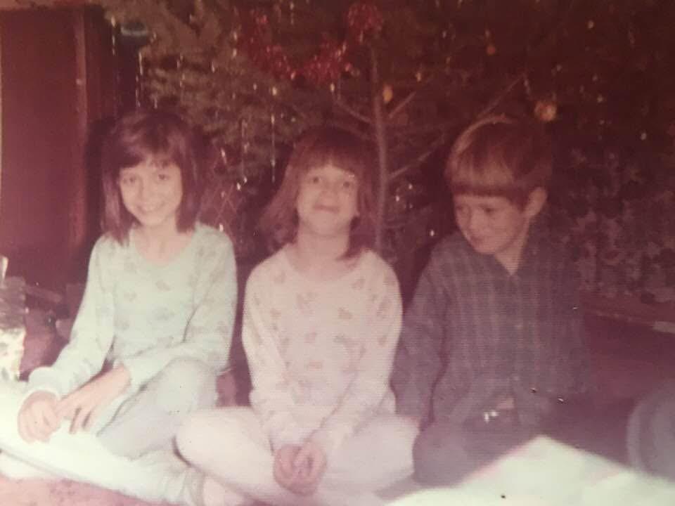 A group of children sitting in front of a tree