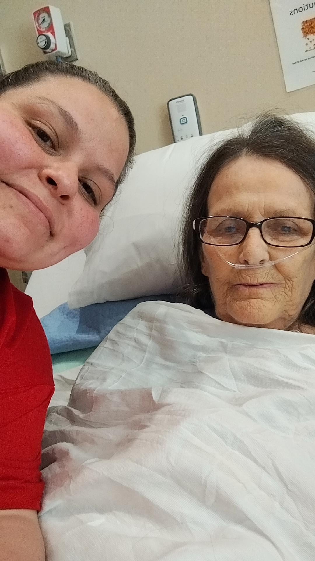 A woman in a hospital bed with a woman smiling