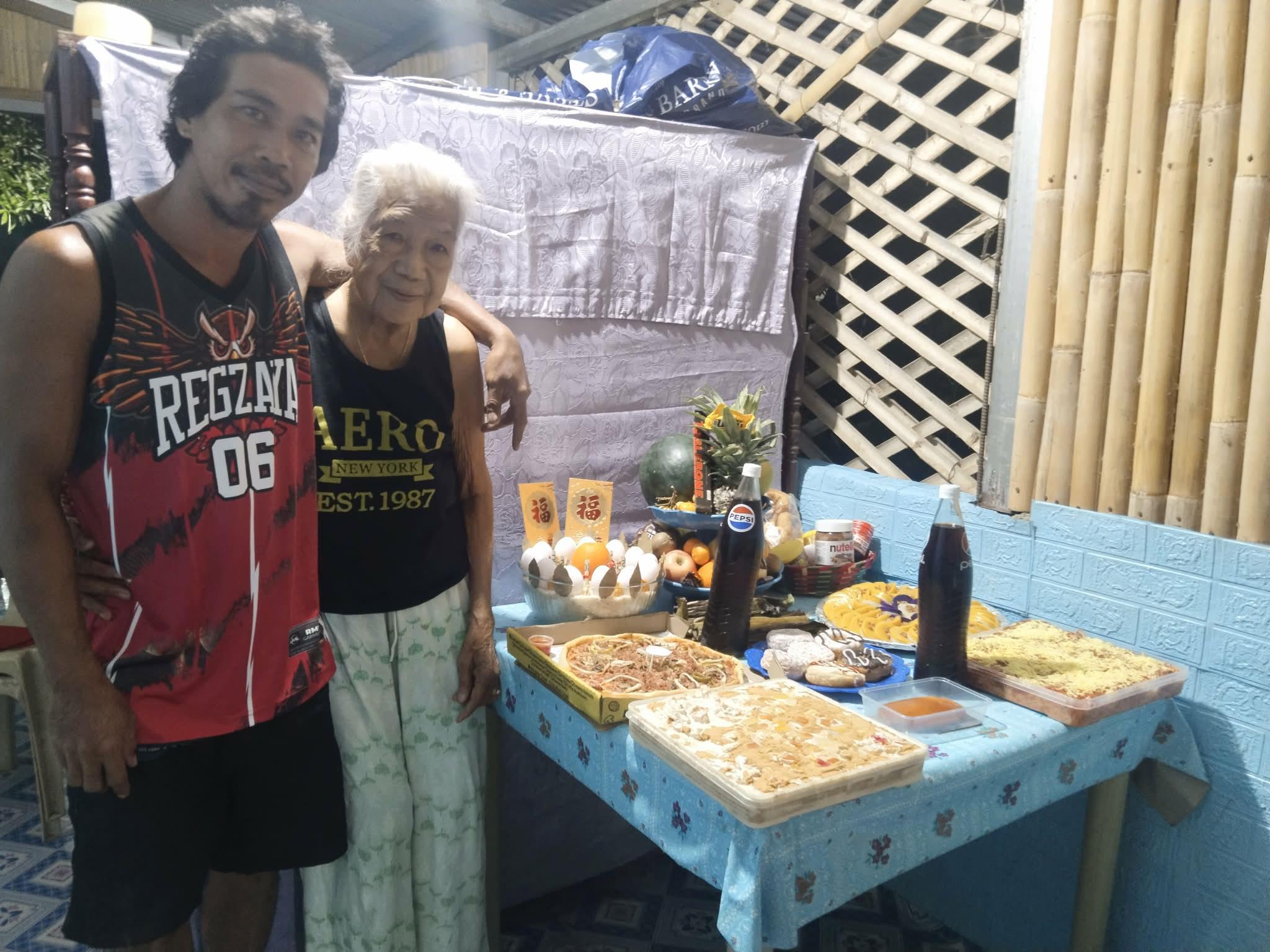 A man and woman standing next to a table with food