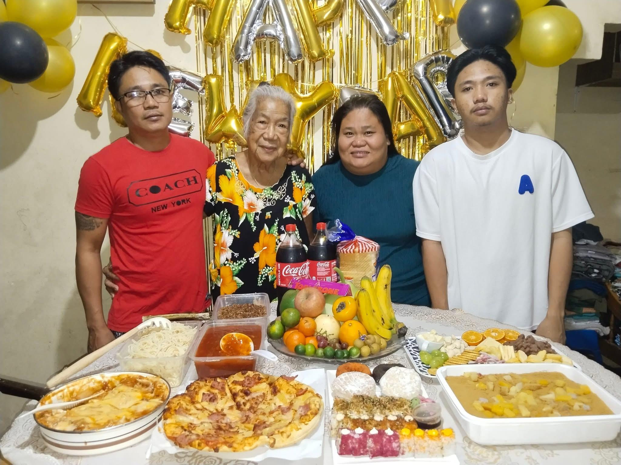 A group of people standing around a table with food