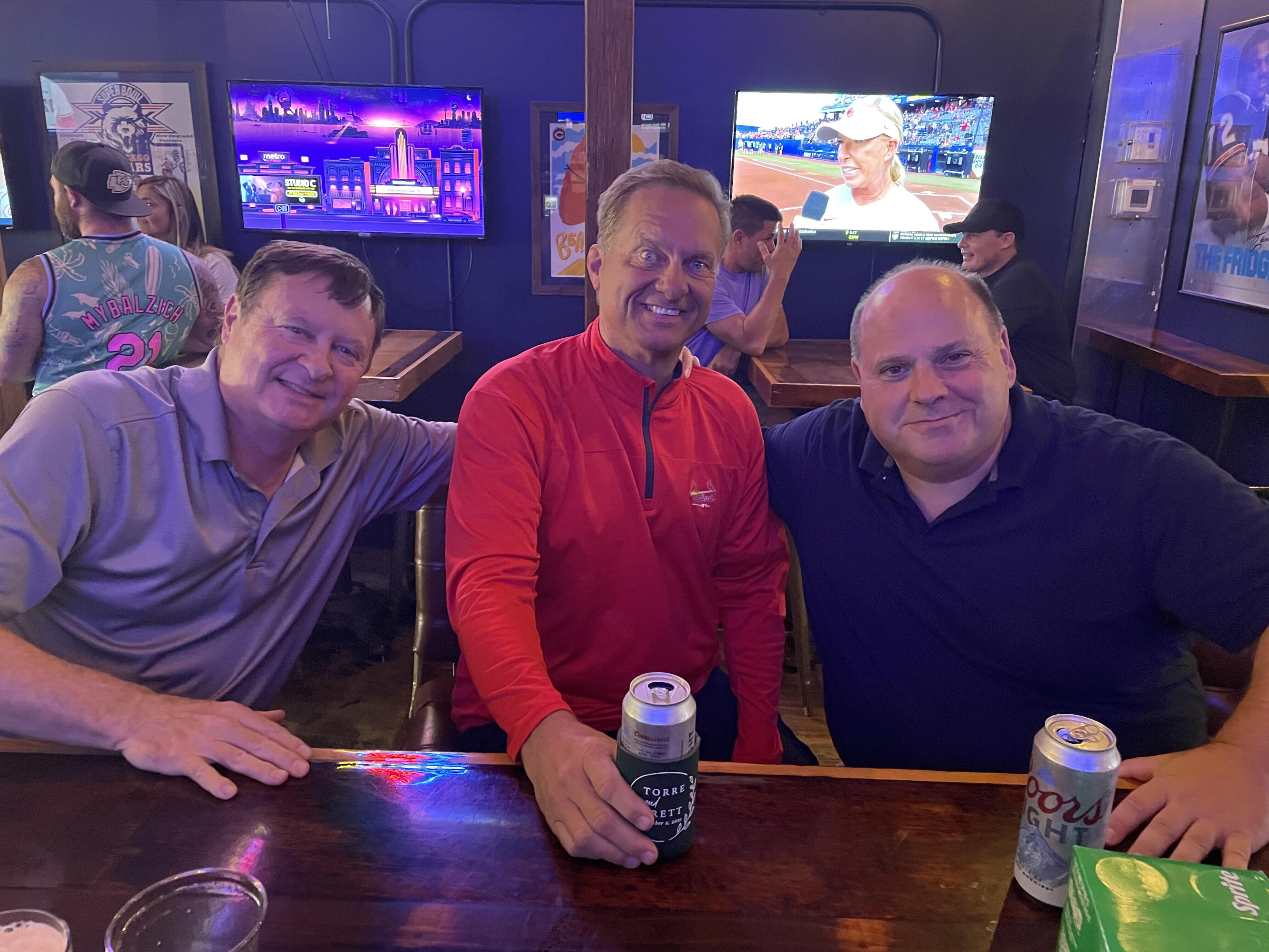 A group of men sitting at a table with beer cans