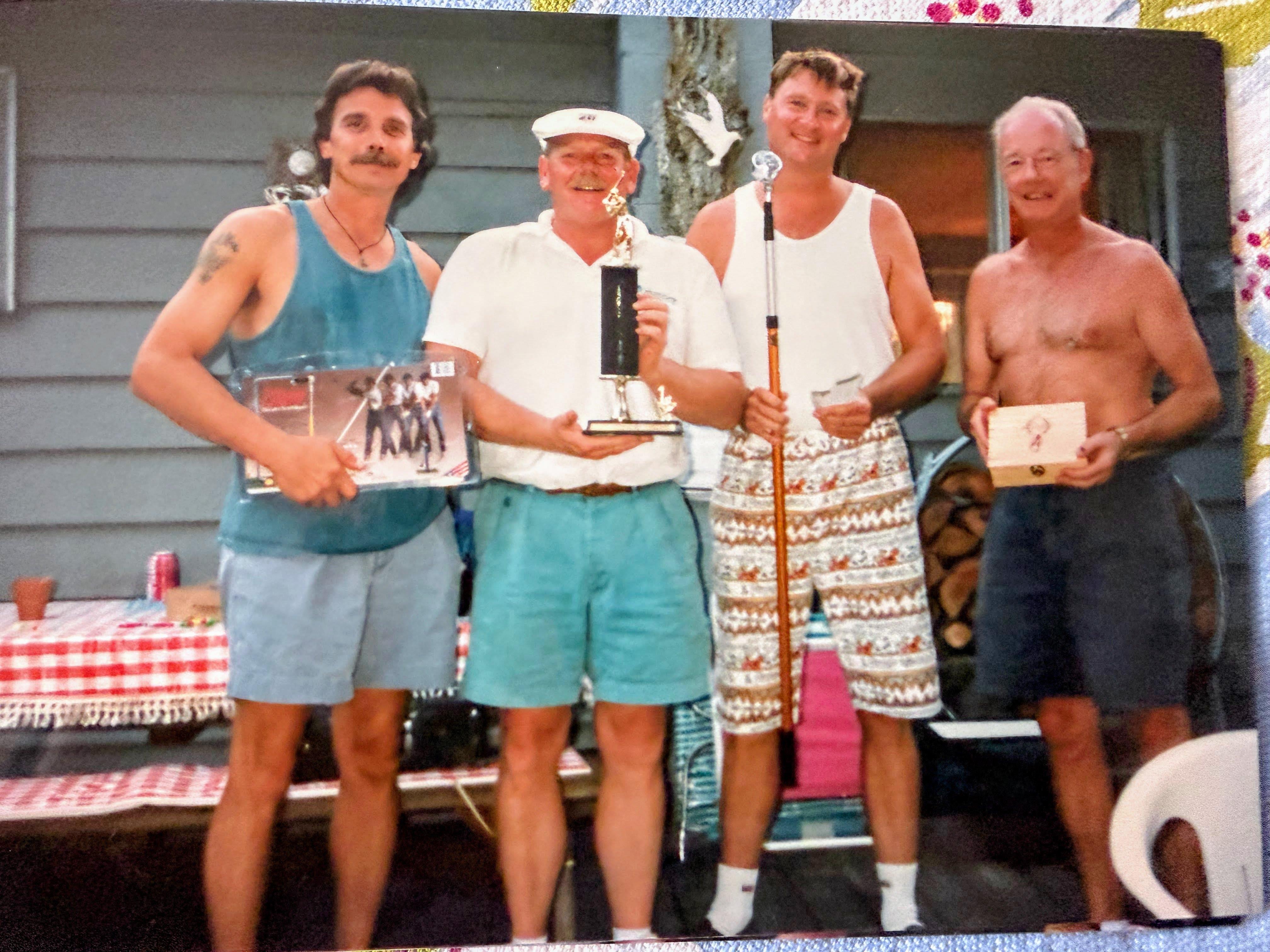 A group of men holding trophies