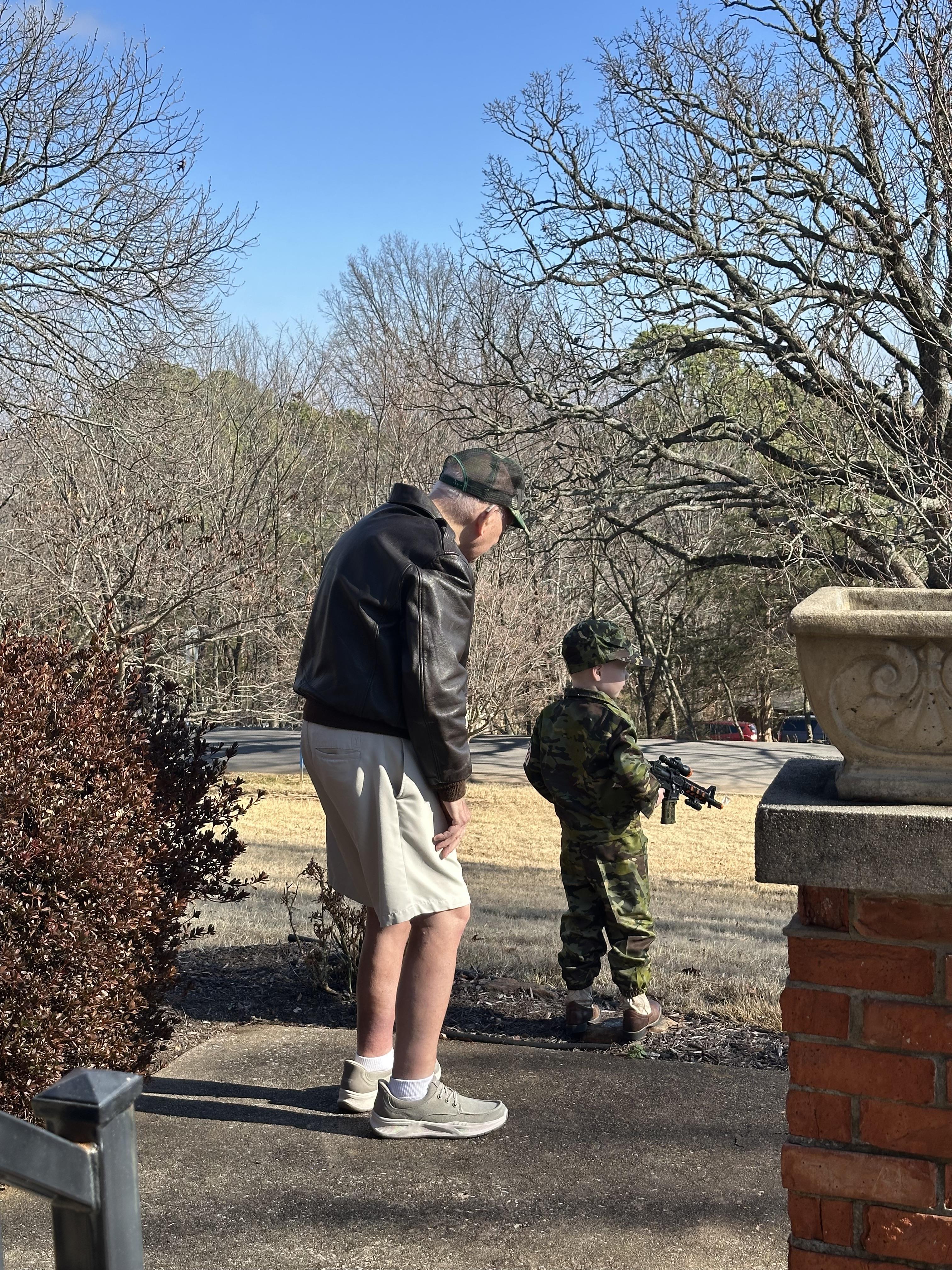 A man and boy looking at a gun