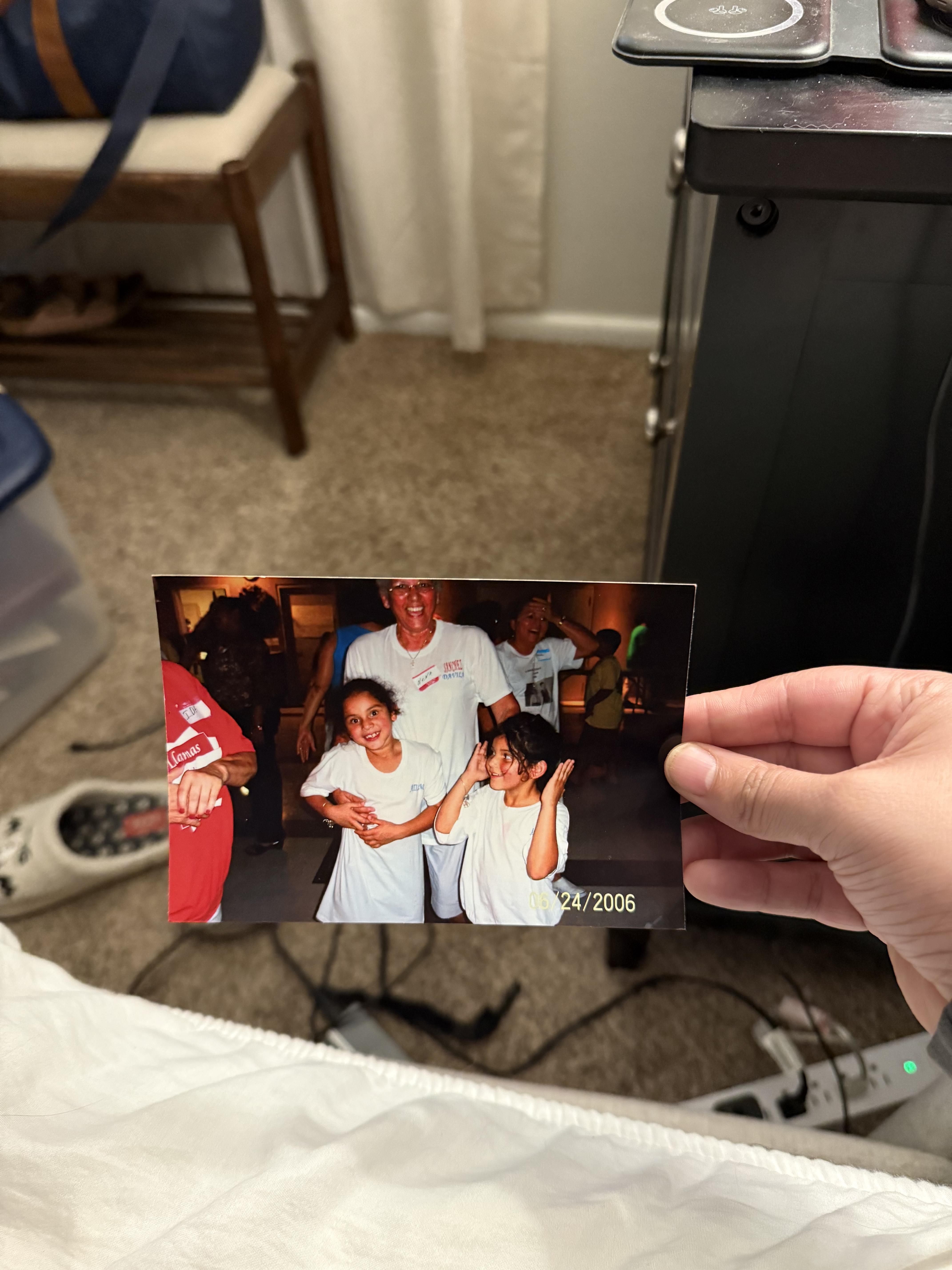 A hand holding a photo of a group of people