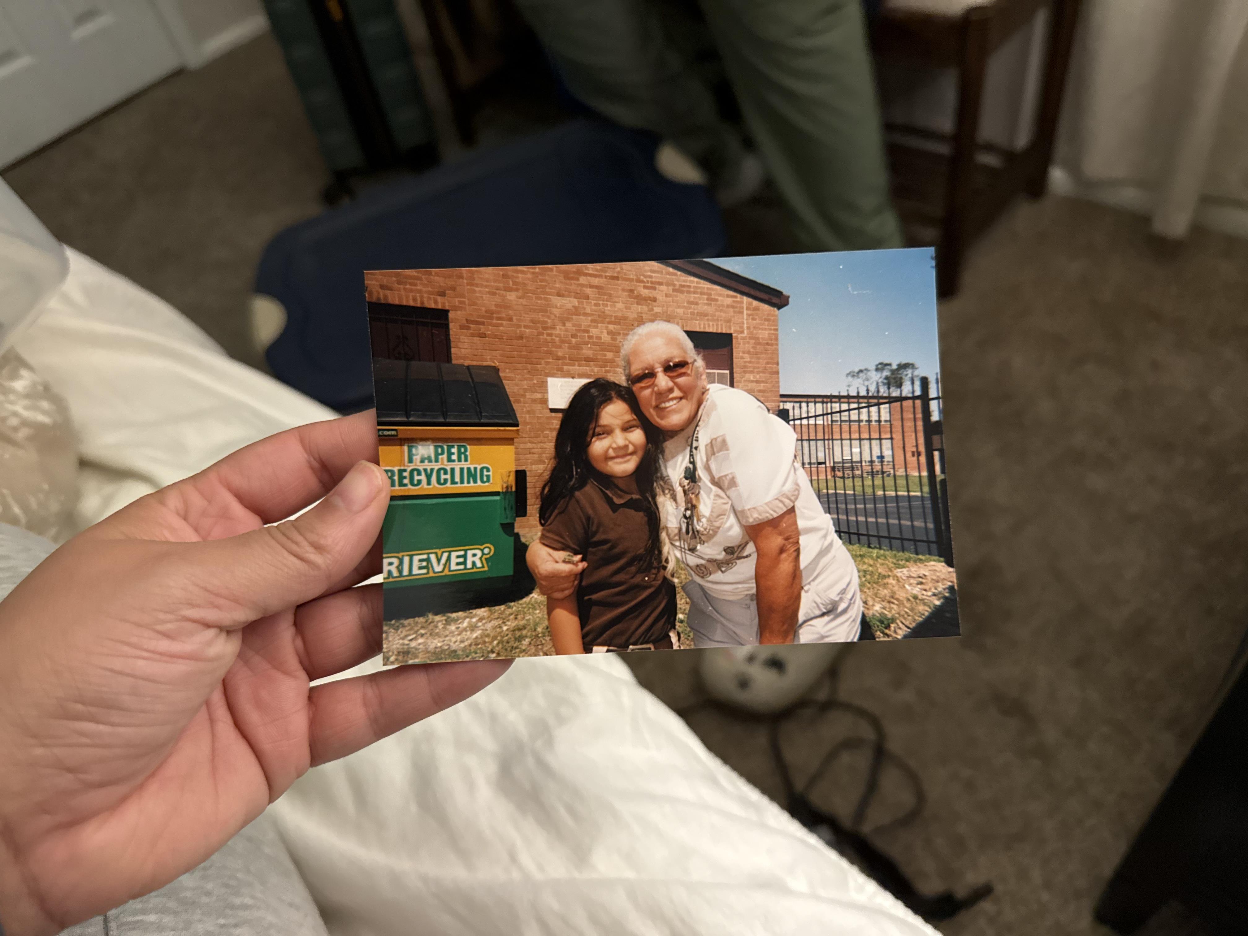 A hand holding a photo of a man and a woman