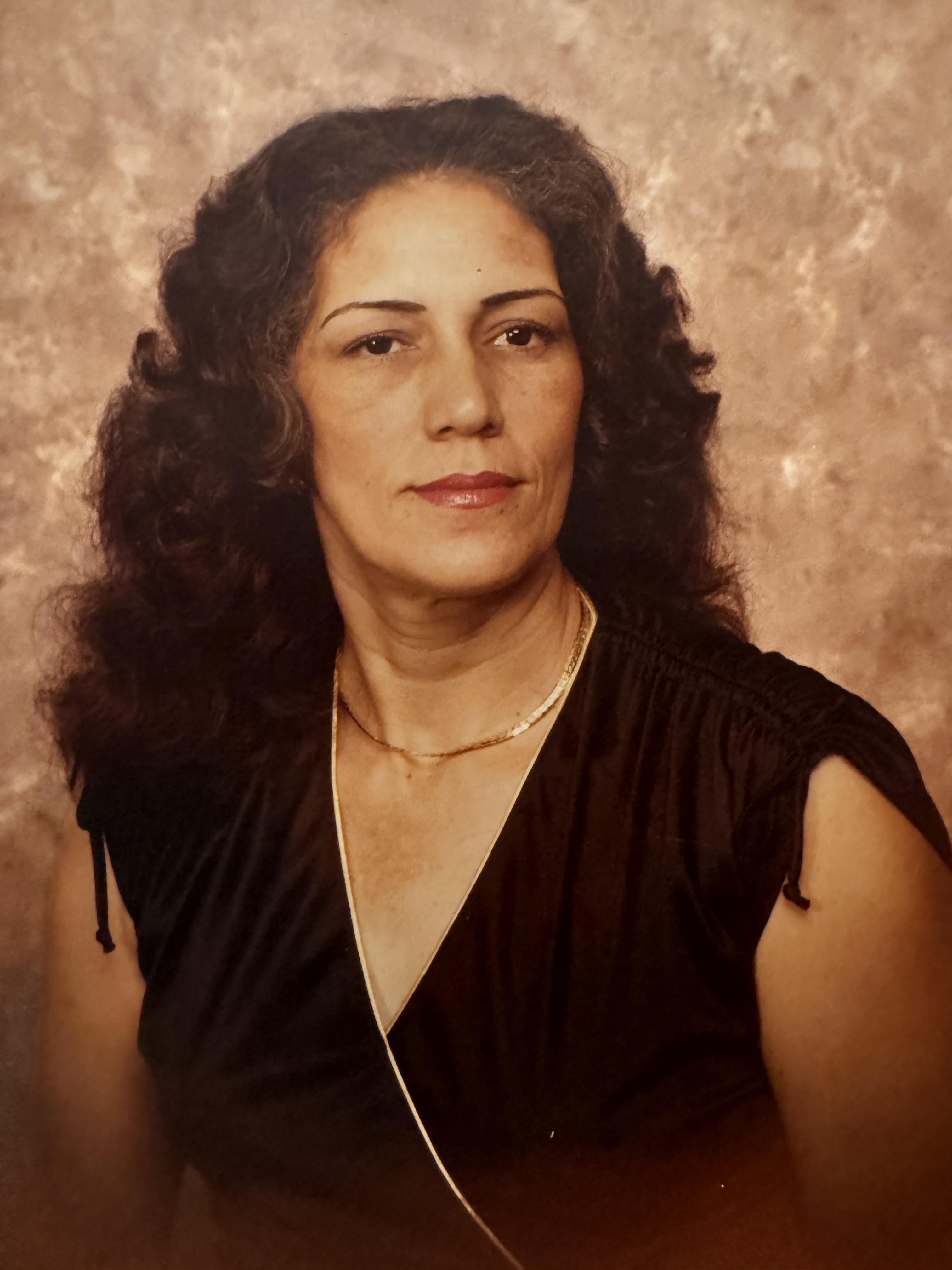 A woman with long curly hair wearing a black dress