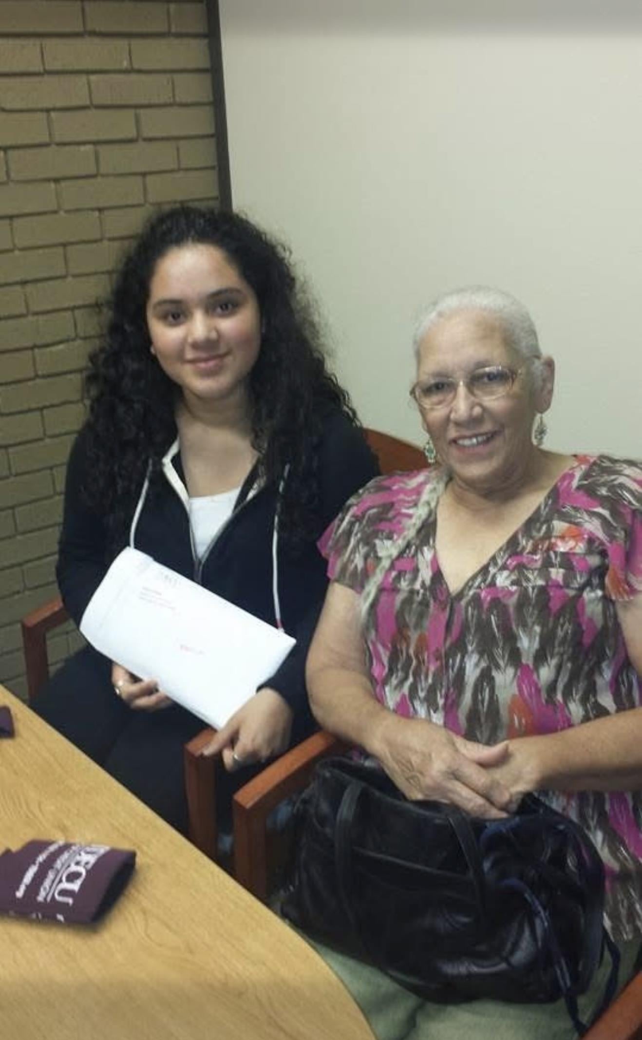 A woman and a young woman sitting in chairs
