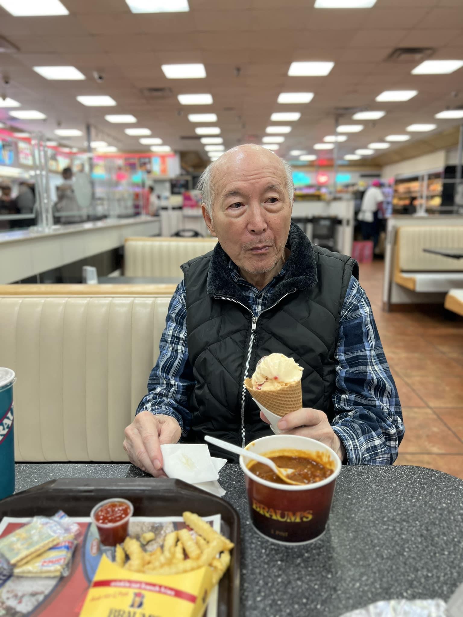 A man sitting at a table eating ice cream