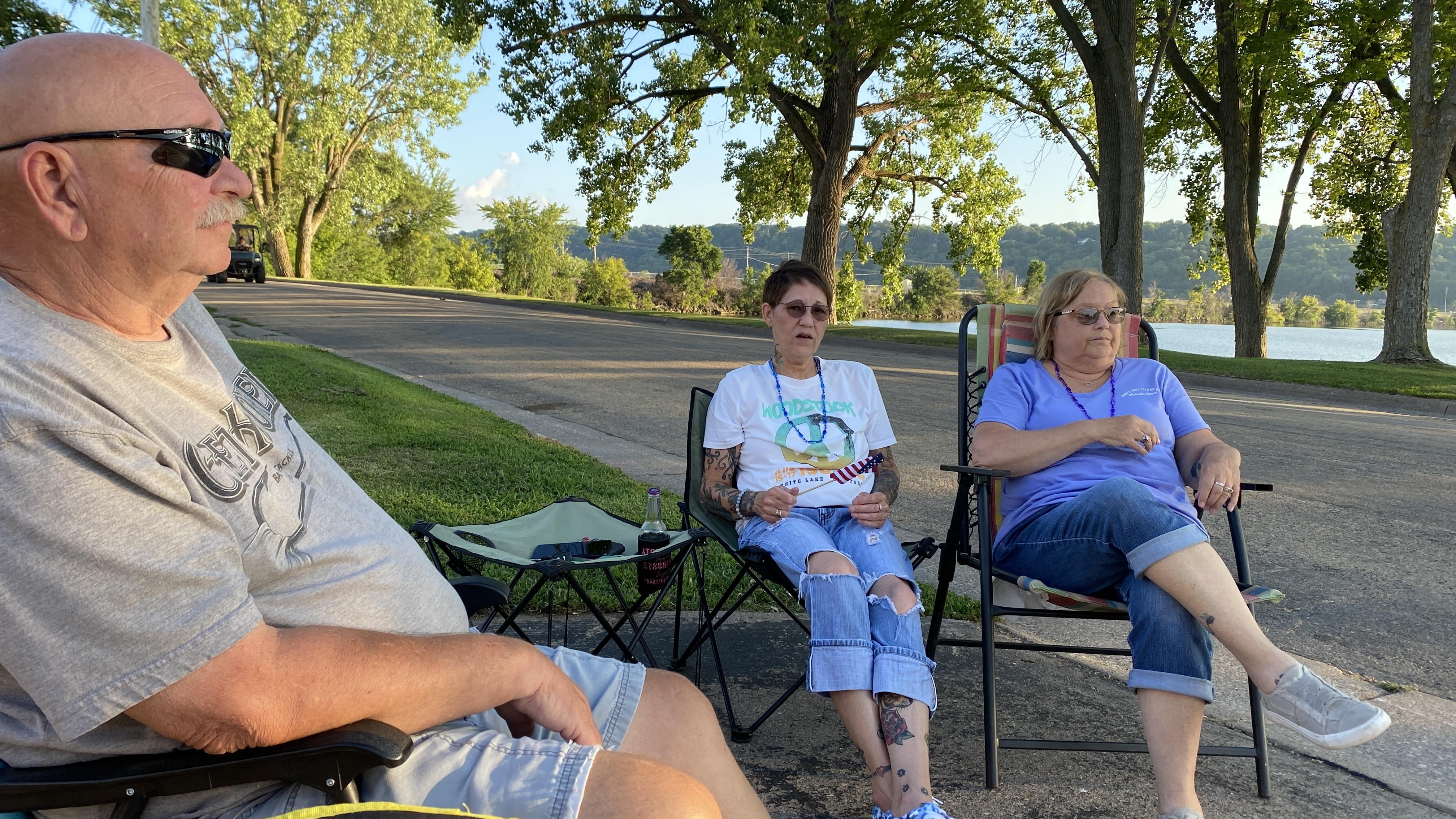 A group of people sitting in chairs outside