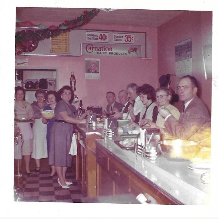 A group of people standing around a bar