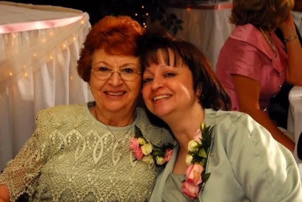 A woman with red hair and a woman with a flower on her shoulder