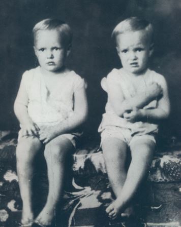 A couple of young children sitting on a rug