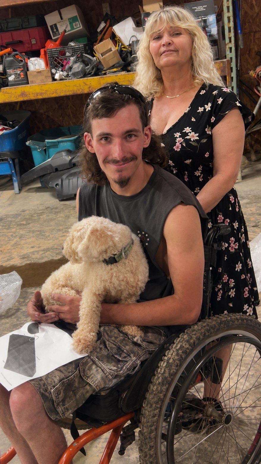 A man in a wheelchair holding a dog