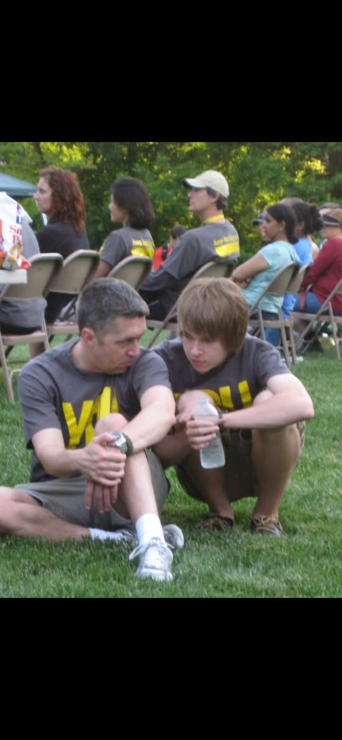 A man and boy sitting on the grass