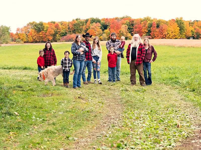 A group of people standing in a field with a dog