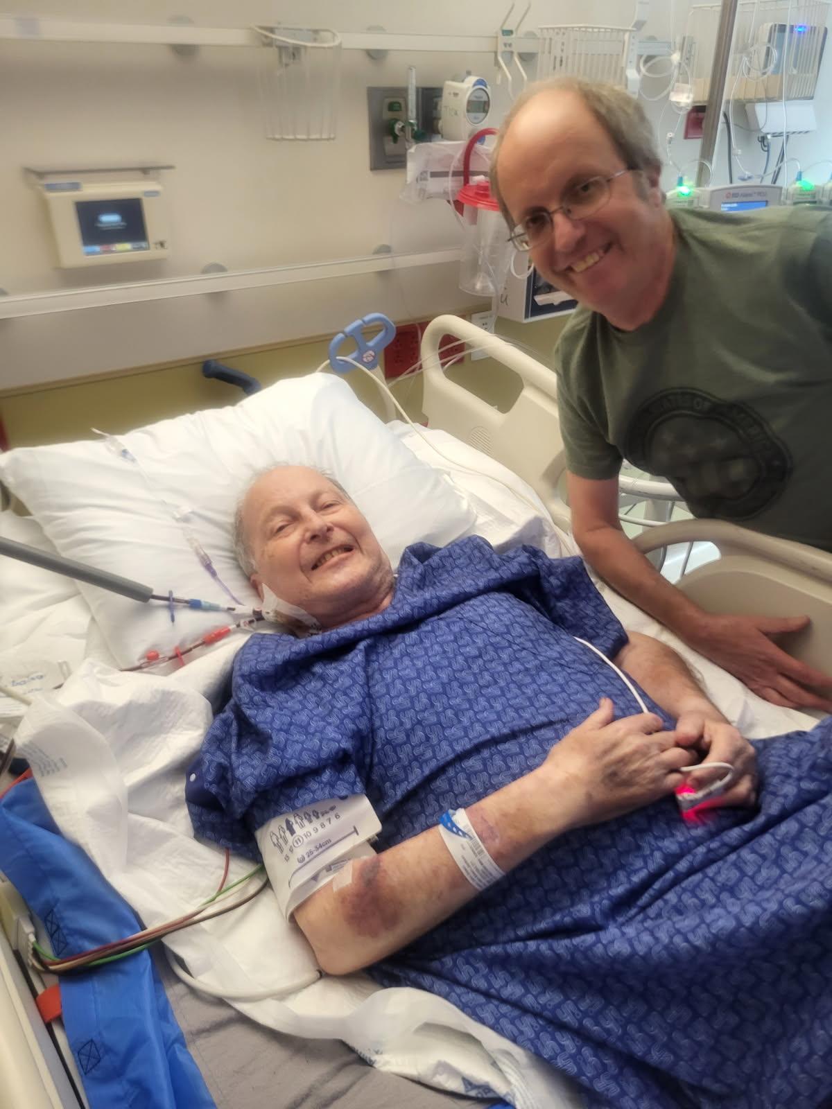 A man smiling next to a woman in a hospital bed