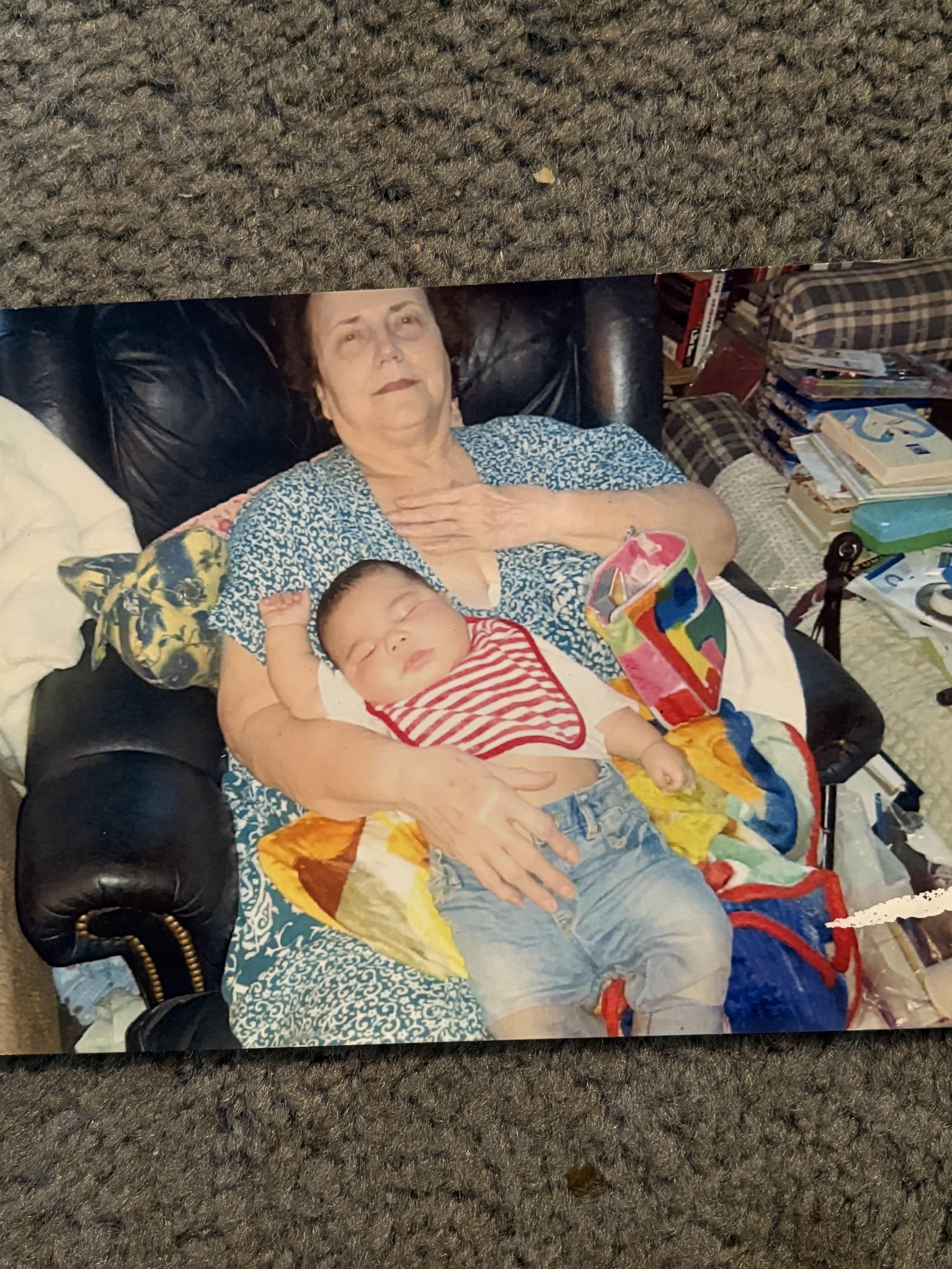 A woman lying on a couch holding a baby